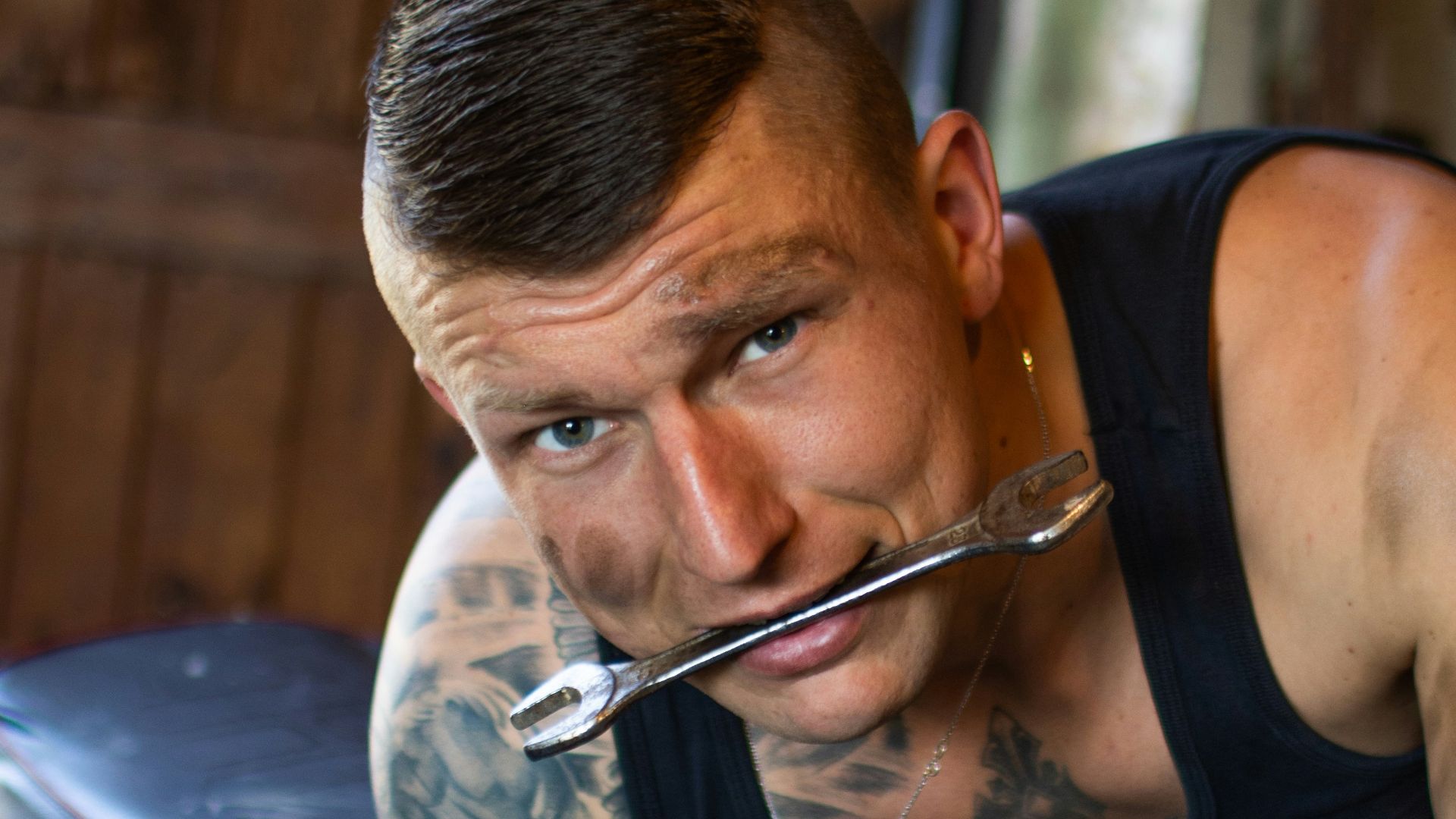 man in black tank top playing guitar