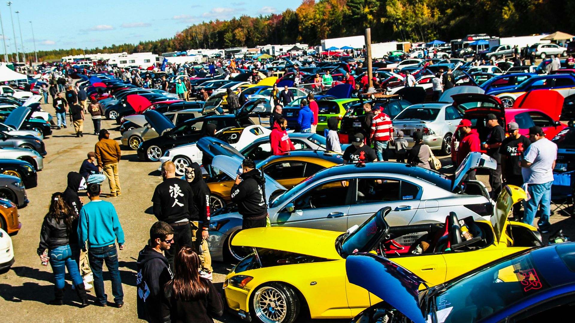 people standing beside blue and yellow cars during daytime