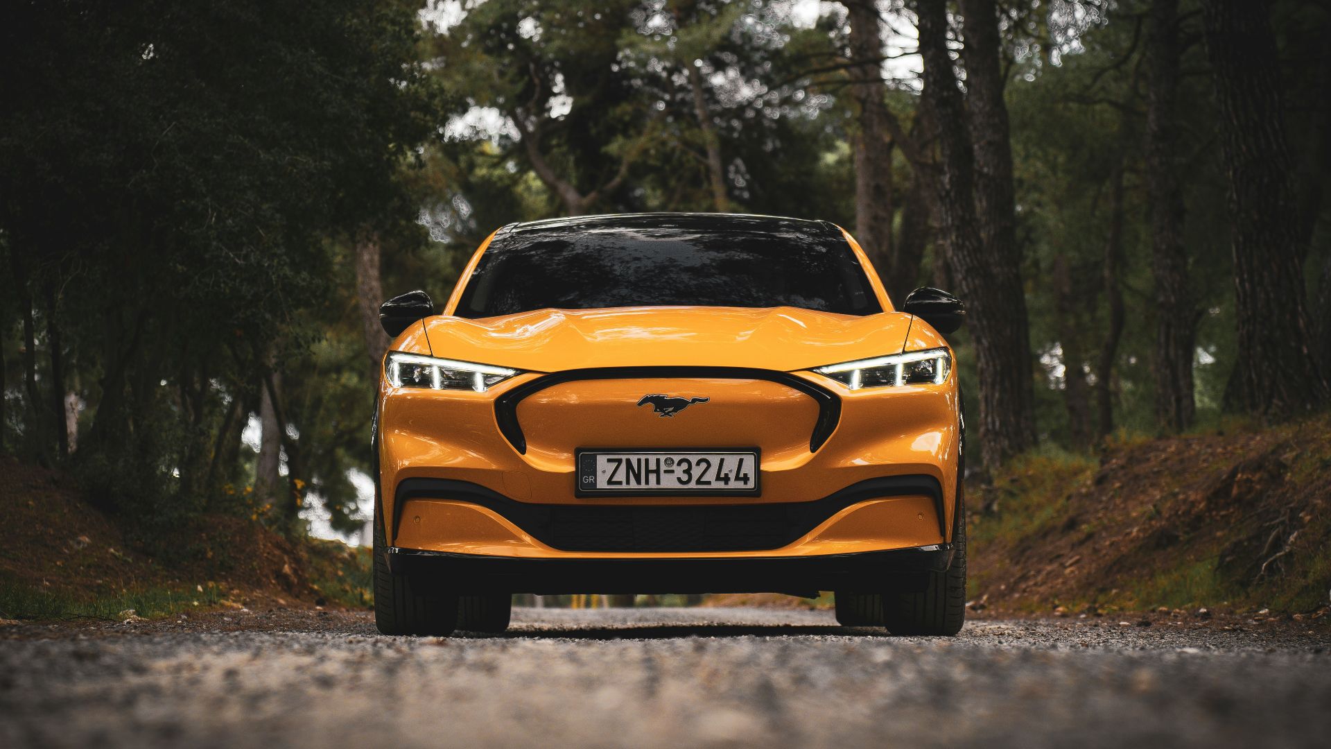 a yellow car is driving down the road