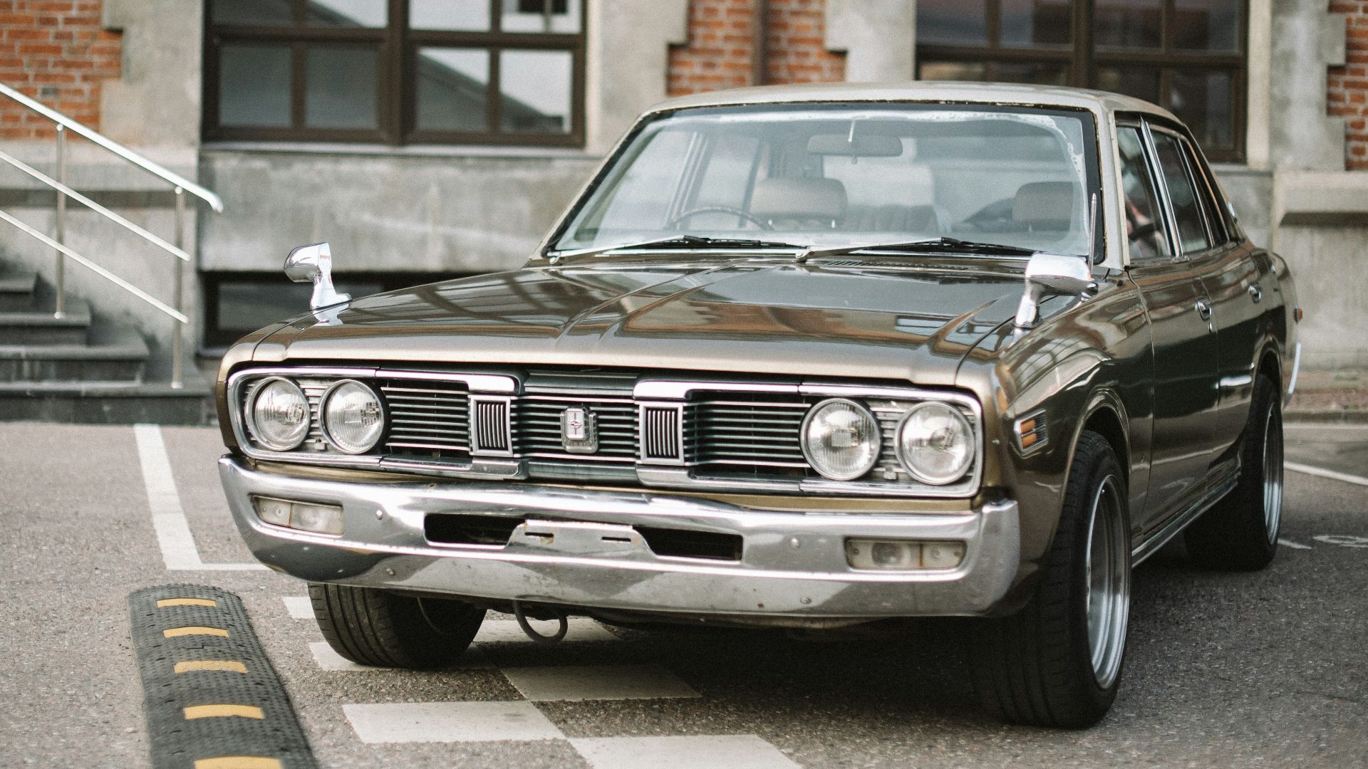silver mercedes benz car parked beside brown brick building during daytime