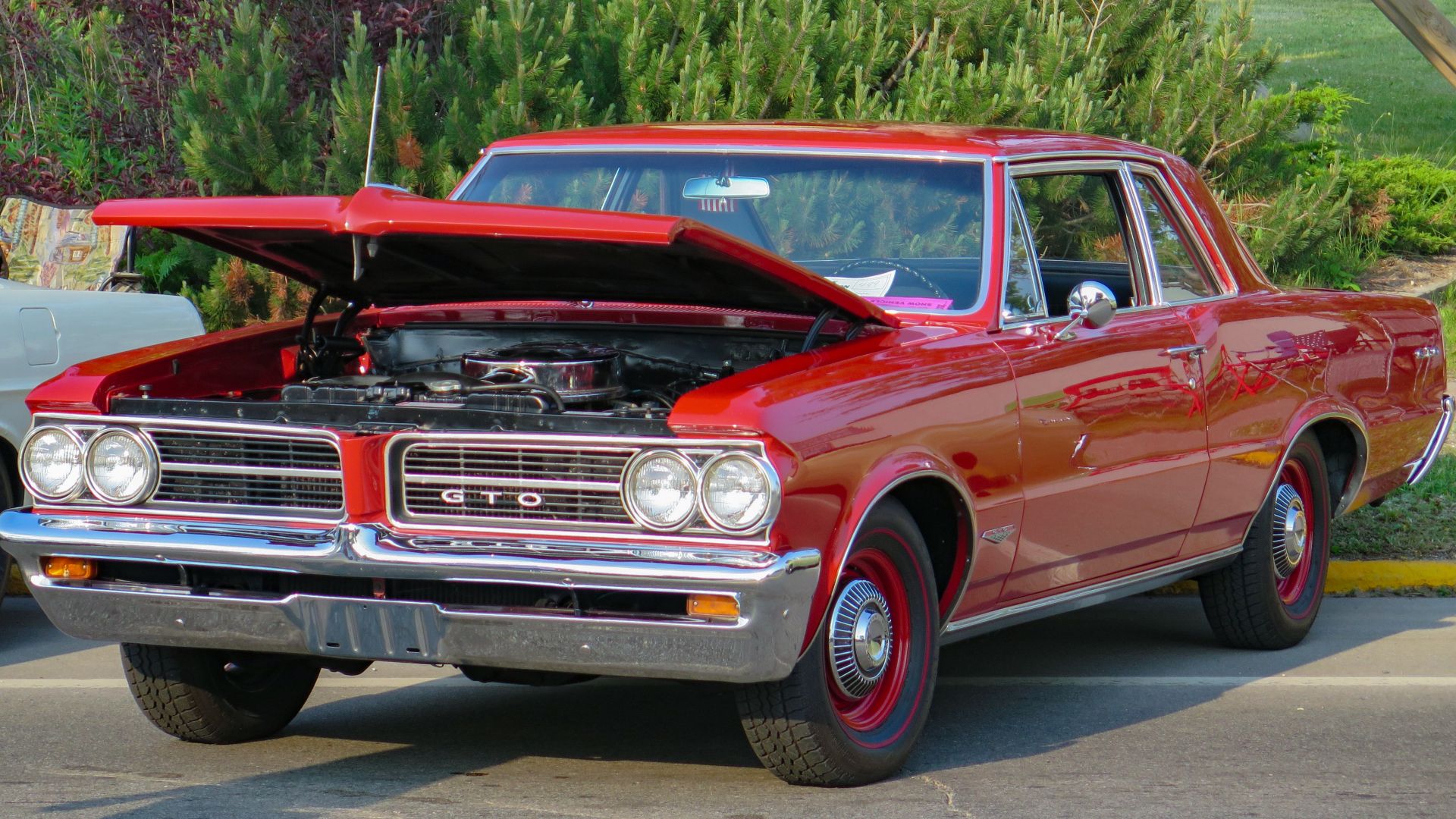 File:1964 Pontiac Tempest LeMans GTO Sports Coupe in Grenadier Red, Front Left (St. Ignace 2023).jpg