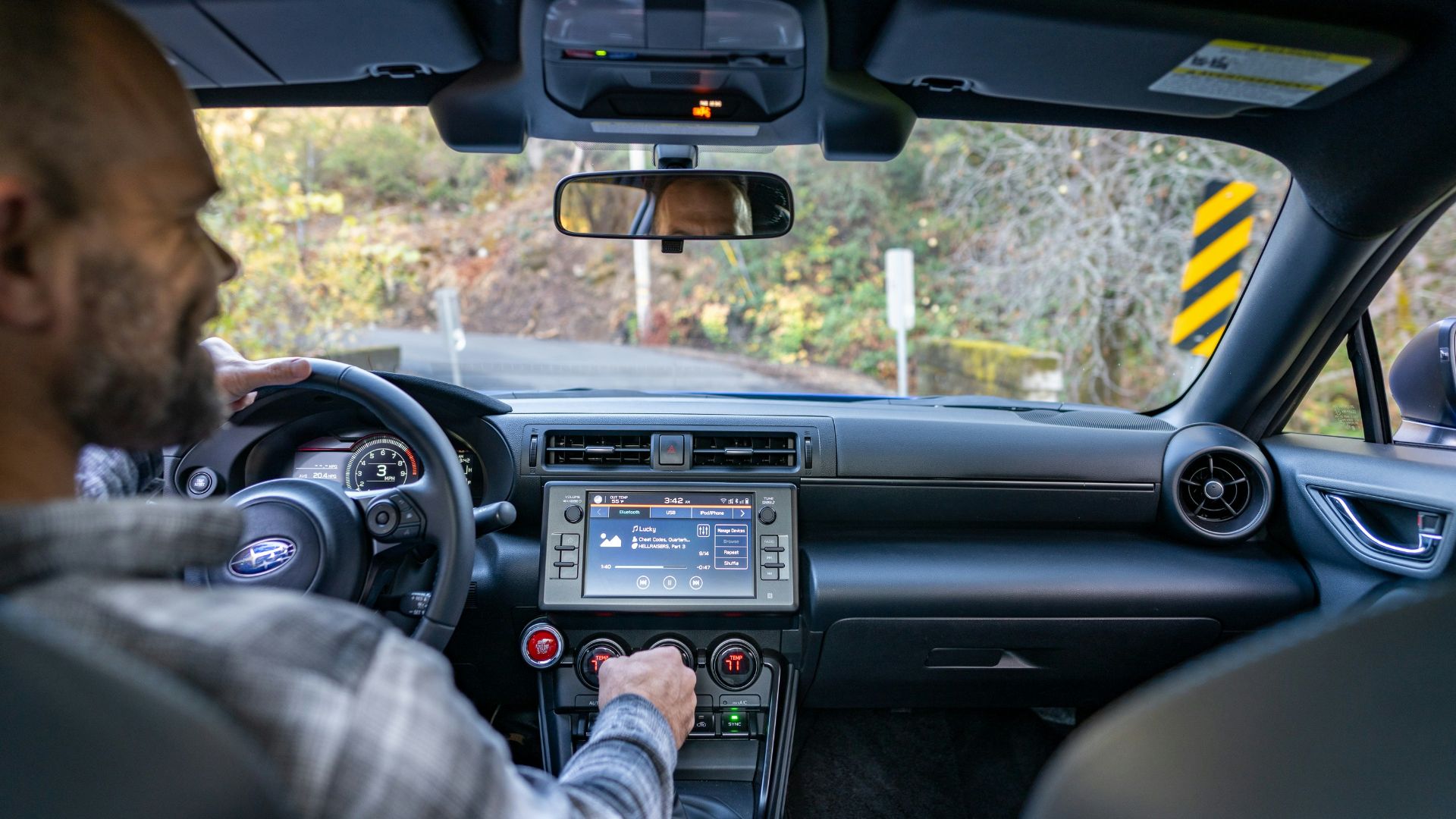 A man driving a car with a gps device in his hand