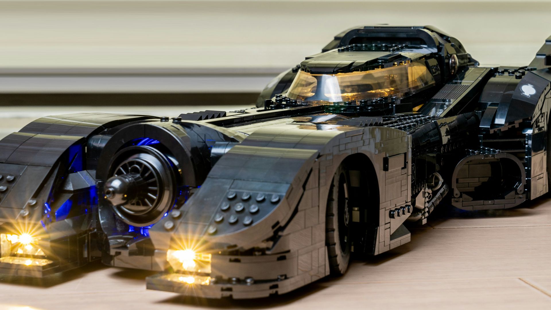 a lego batman car with its lights on