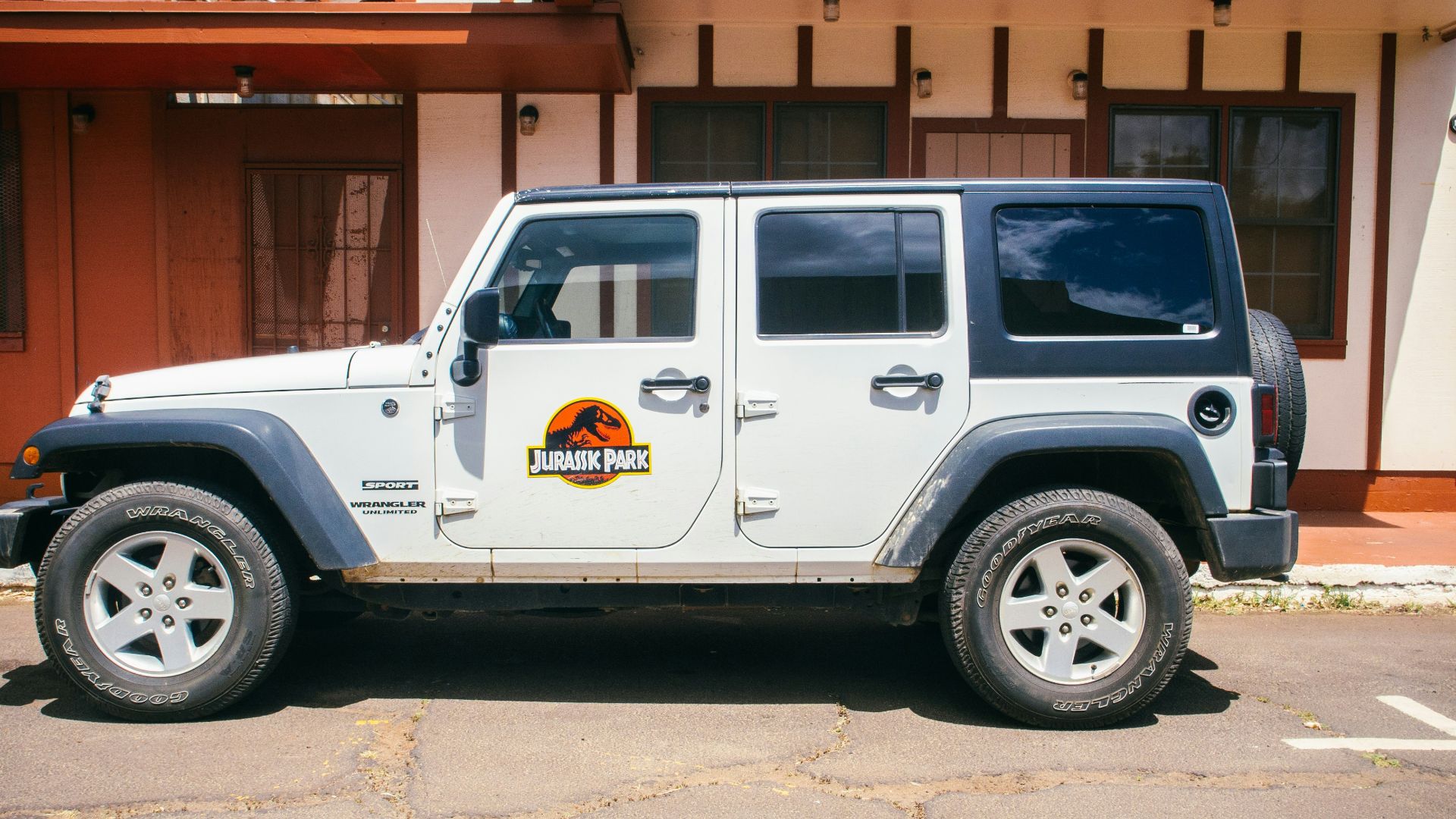 white vehicle parked near white and brown building