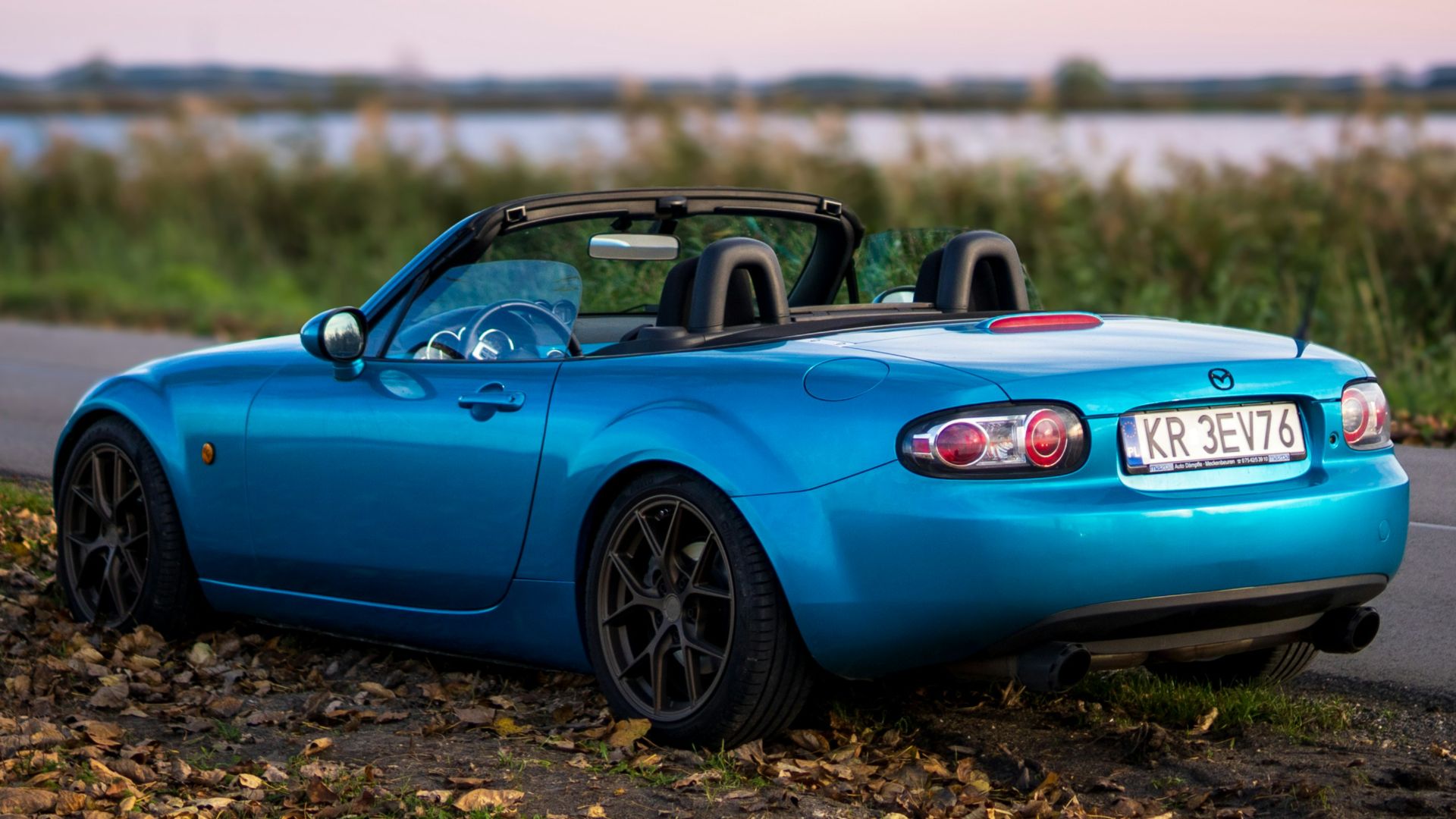 a blue sports car parked on the side of the road