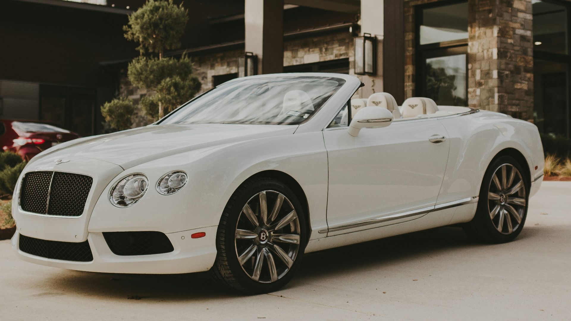 white porsche 911 parked in front of building