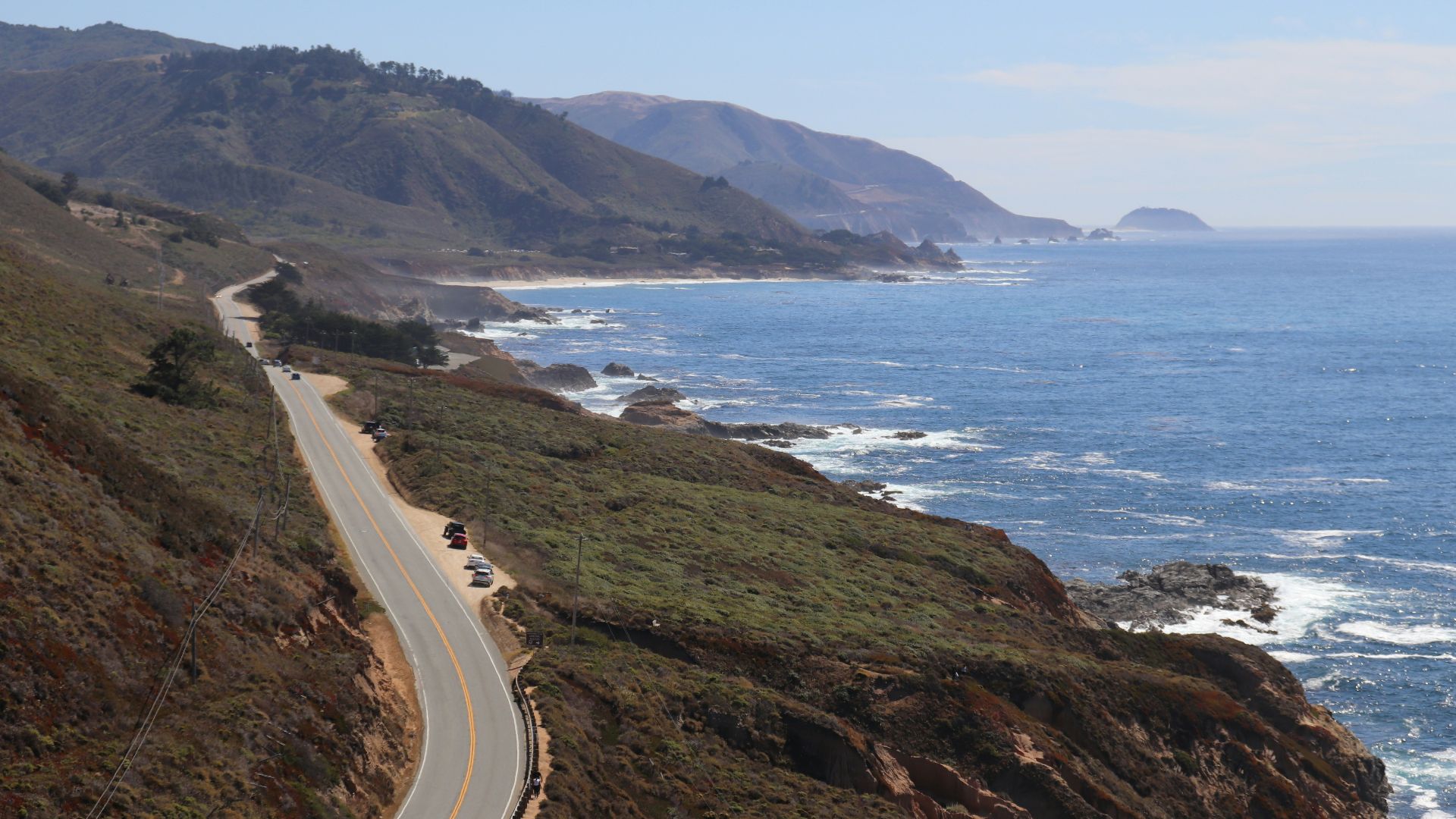 concrete street in between of field and rock formation
