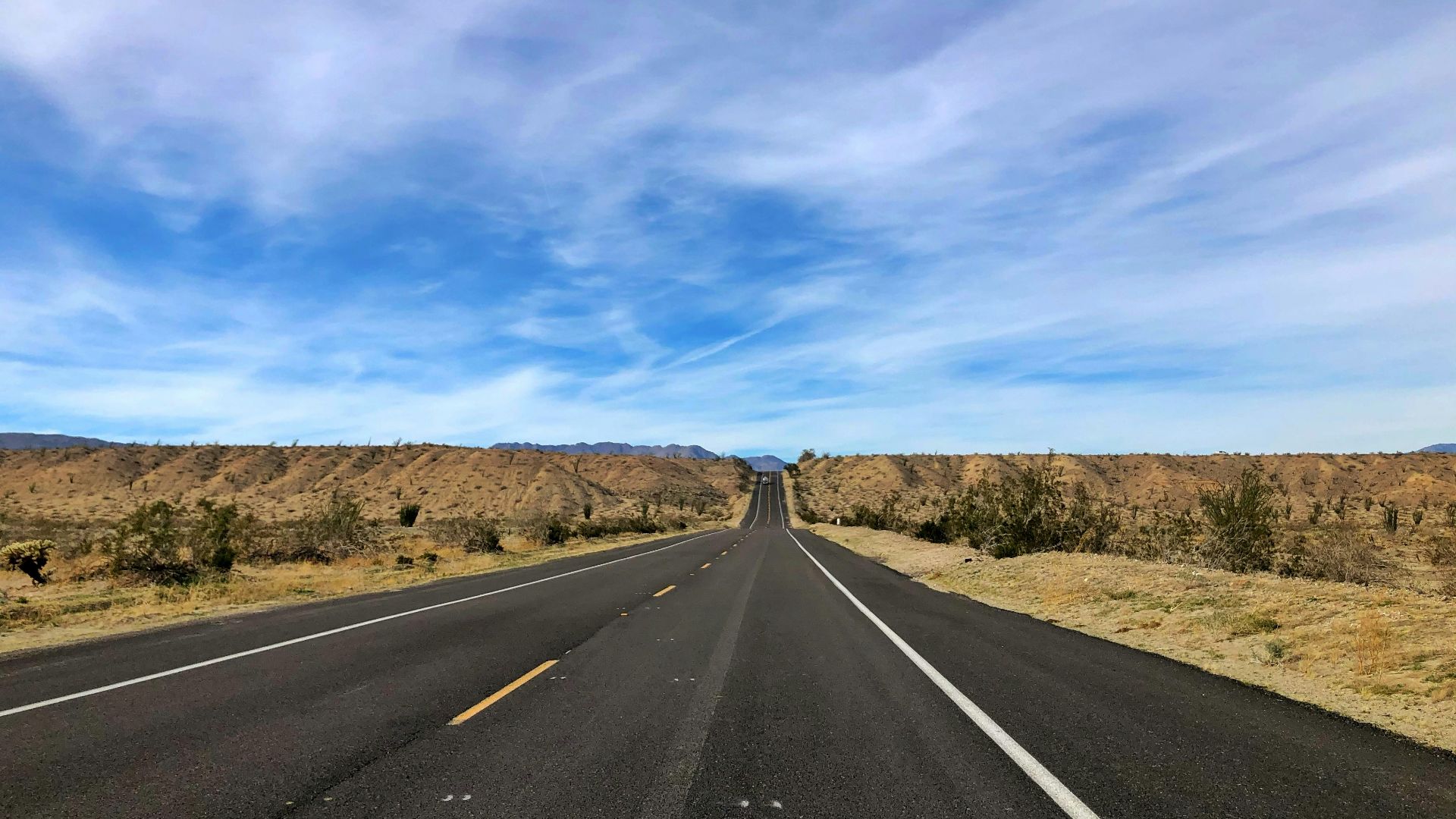 gray asphalt road under blue sky during daytime
