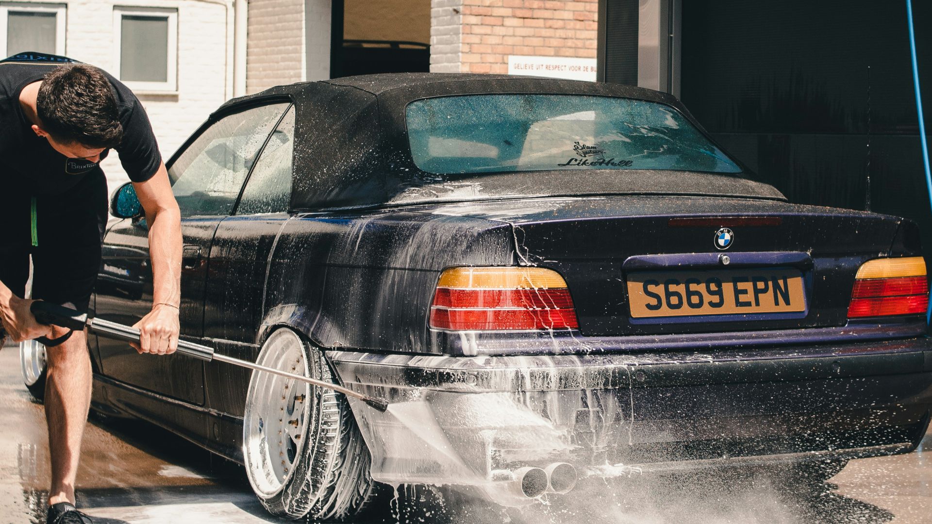 man washing BMW coupe