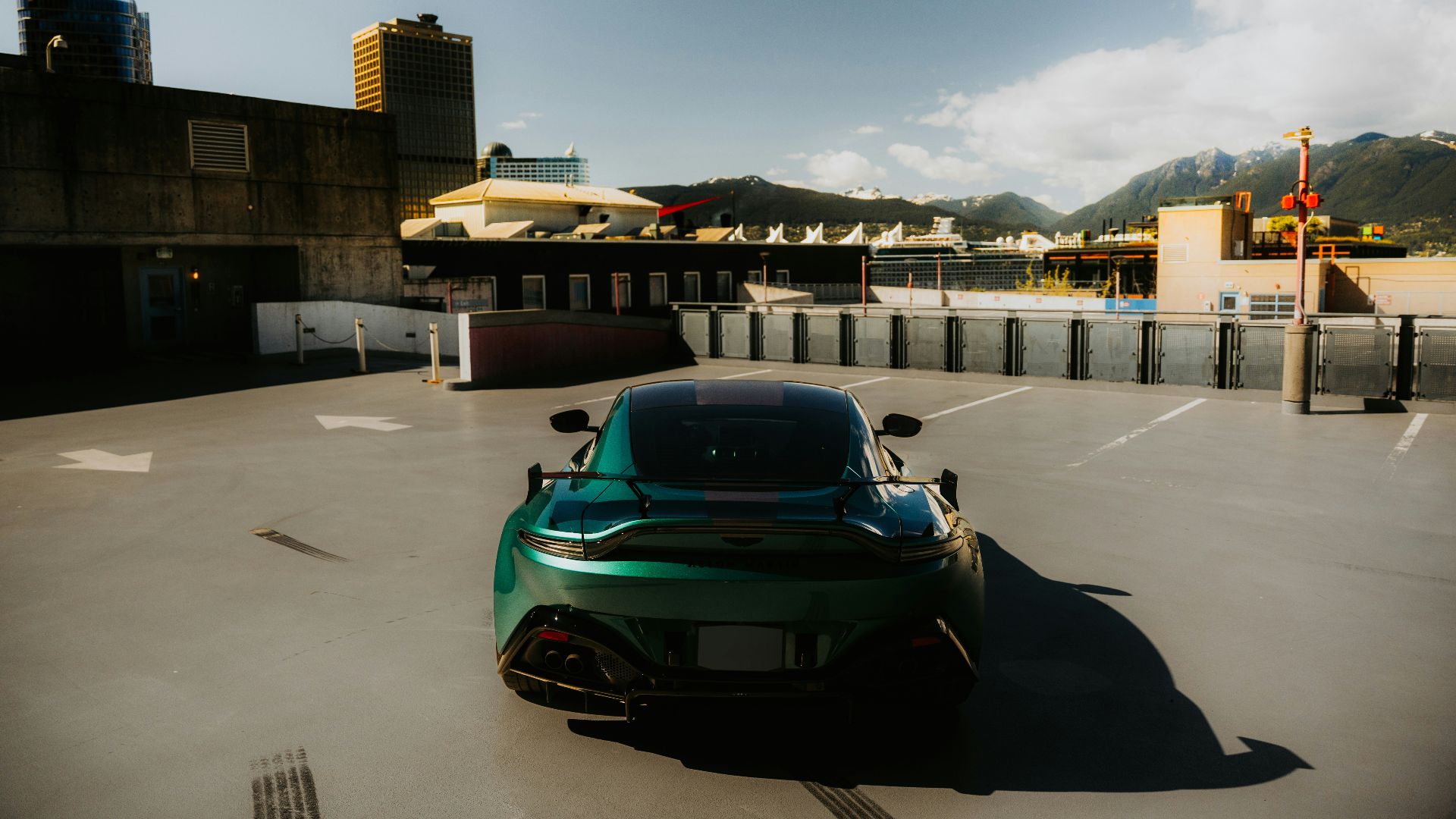 Green sports car parked outdoors on a sunny day.