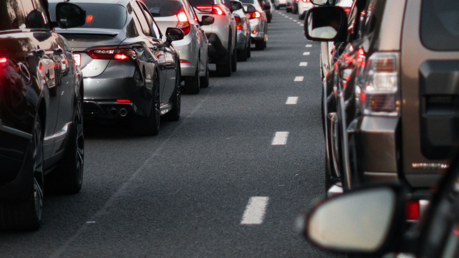 a street filled with lots of traffic next to tall buildings