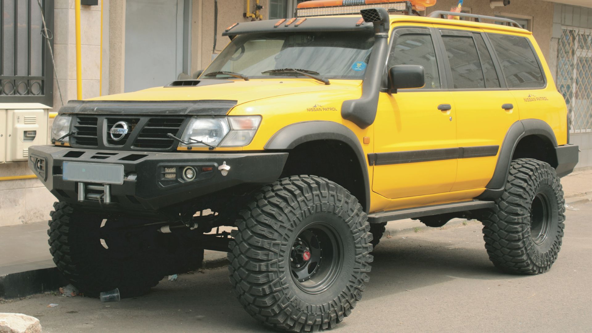 a yellow jeep parked in front of a building