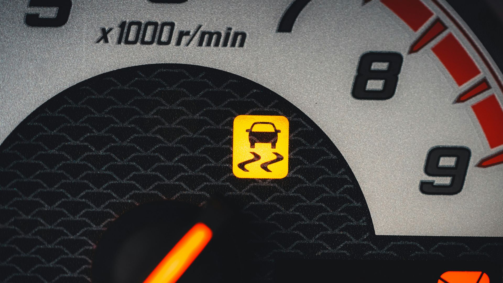a close up of a speedometer with a yellow light
