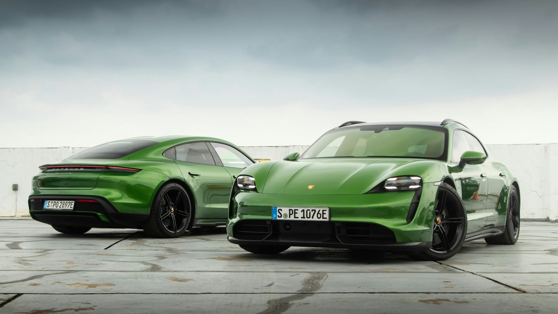a pair of green sports cars parked next to each other