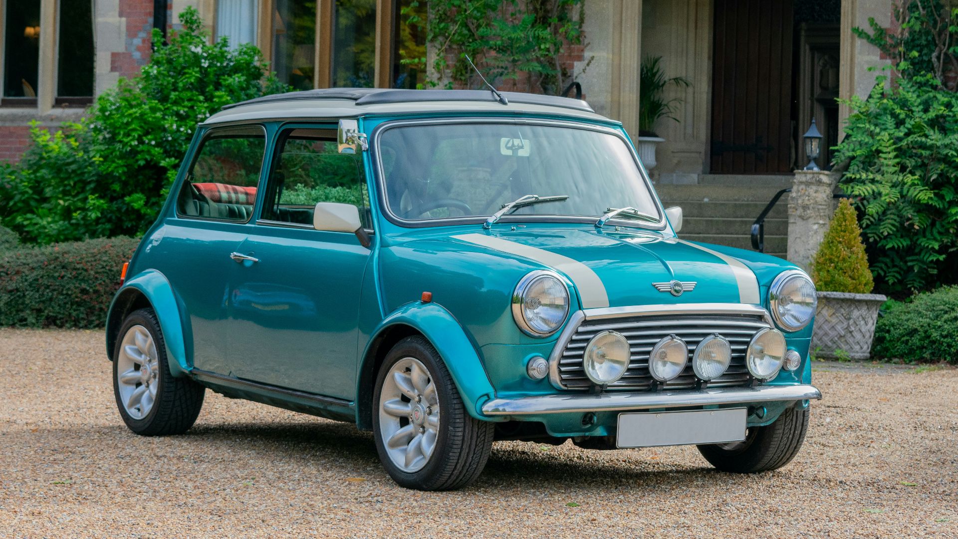 a small blue car parked in front of a building