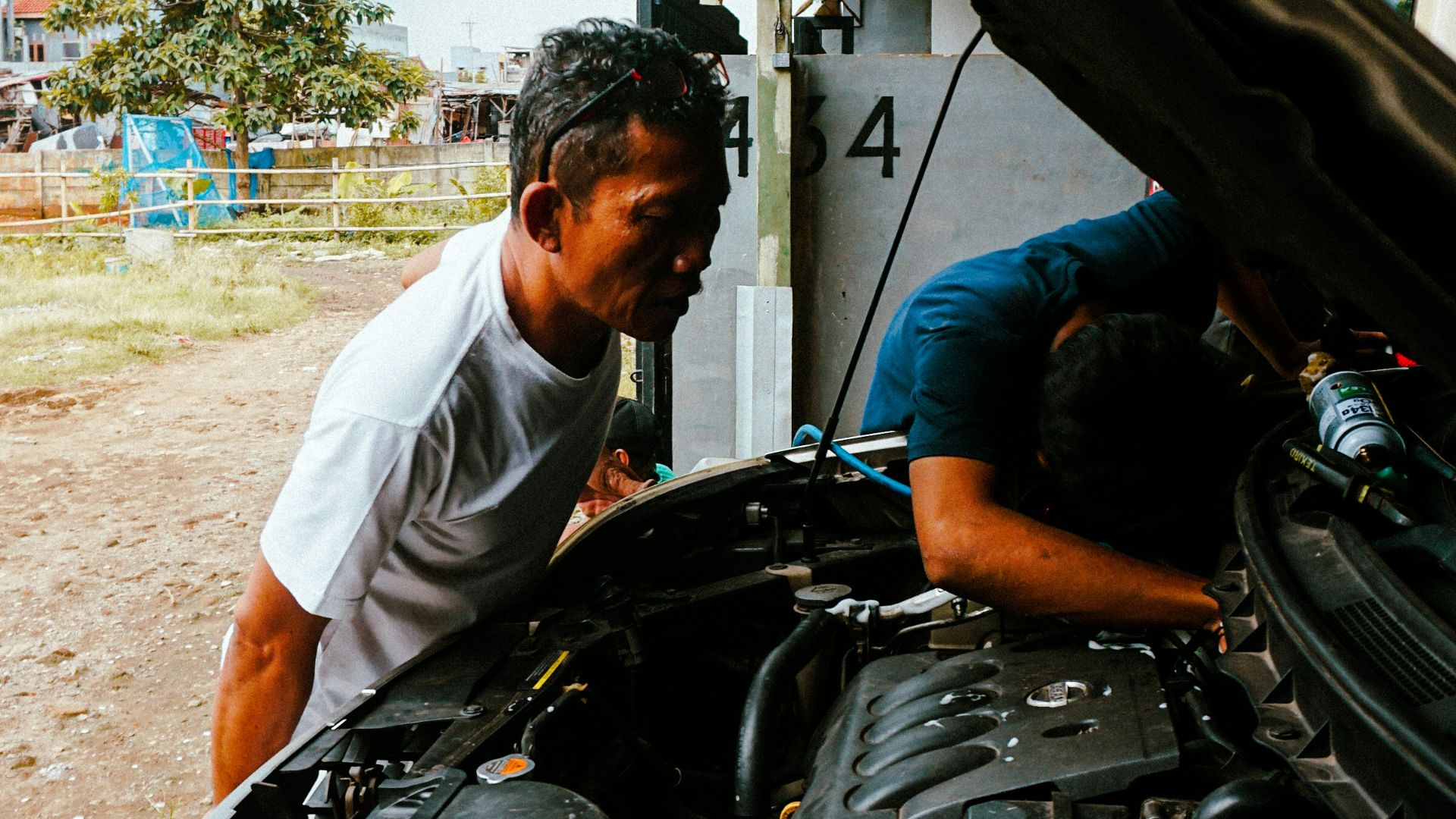 a man working on a car engine in a garage