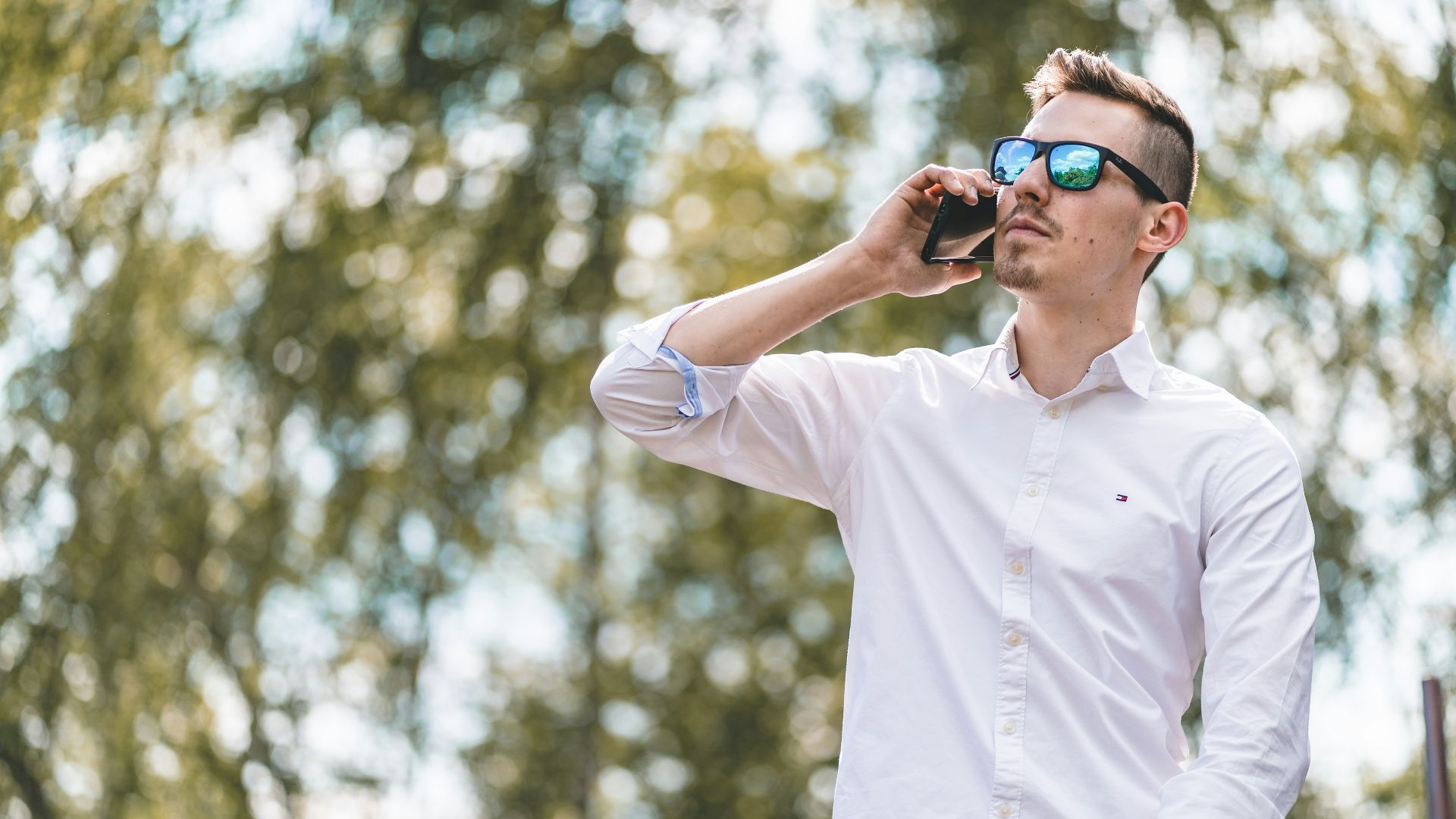 man in white polo shirt wearing blue sunglasses