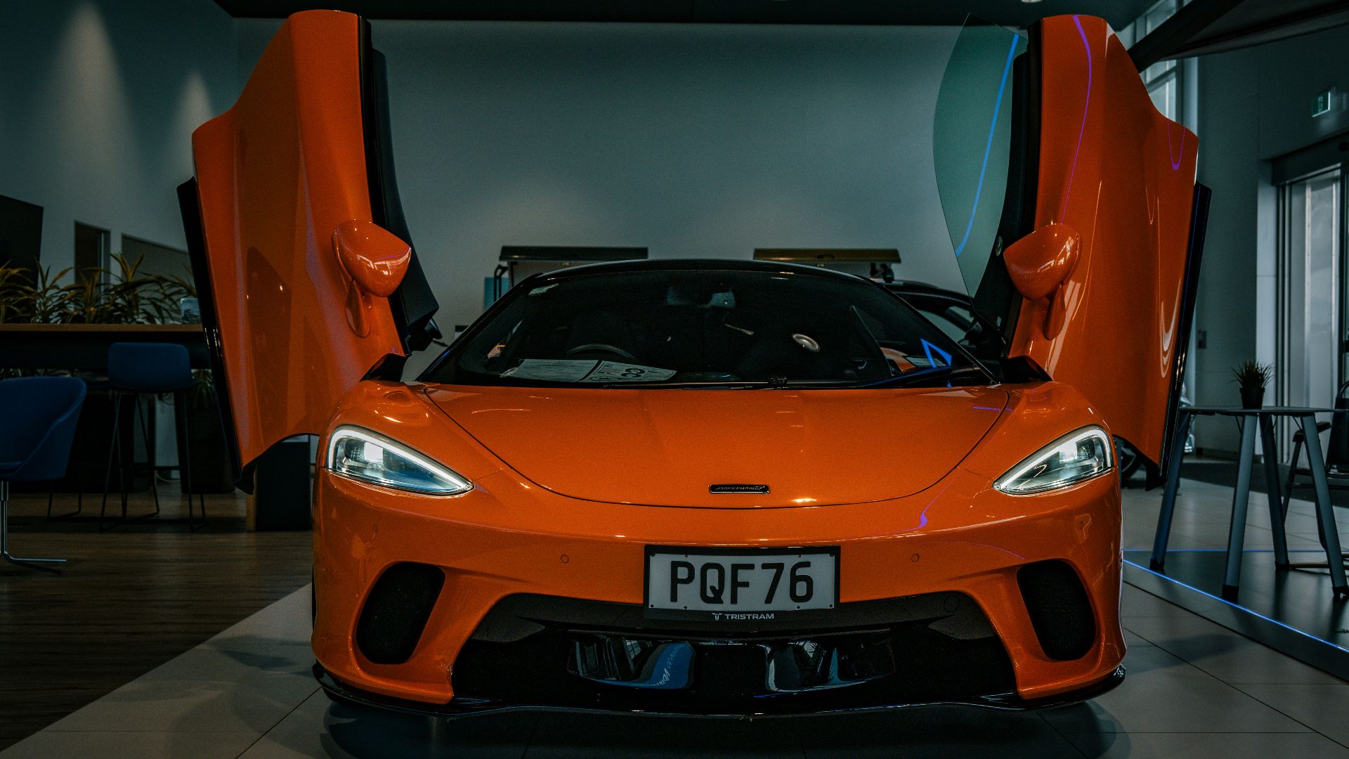 an orange sports car parked inside of a building