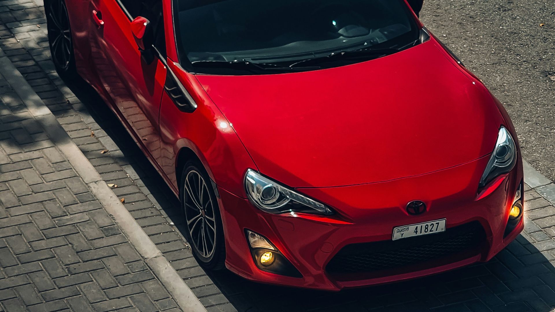 a red sports car parked on the side of the road