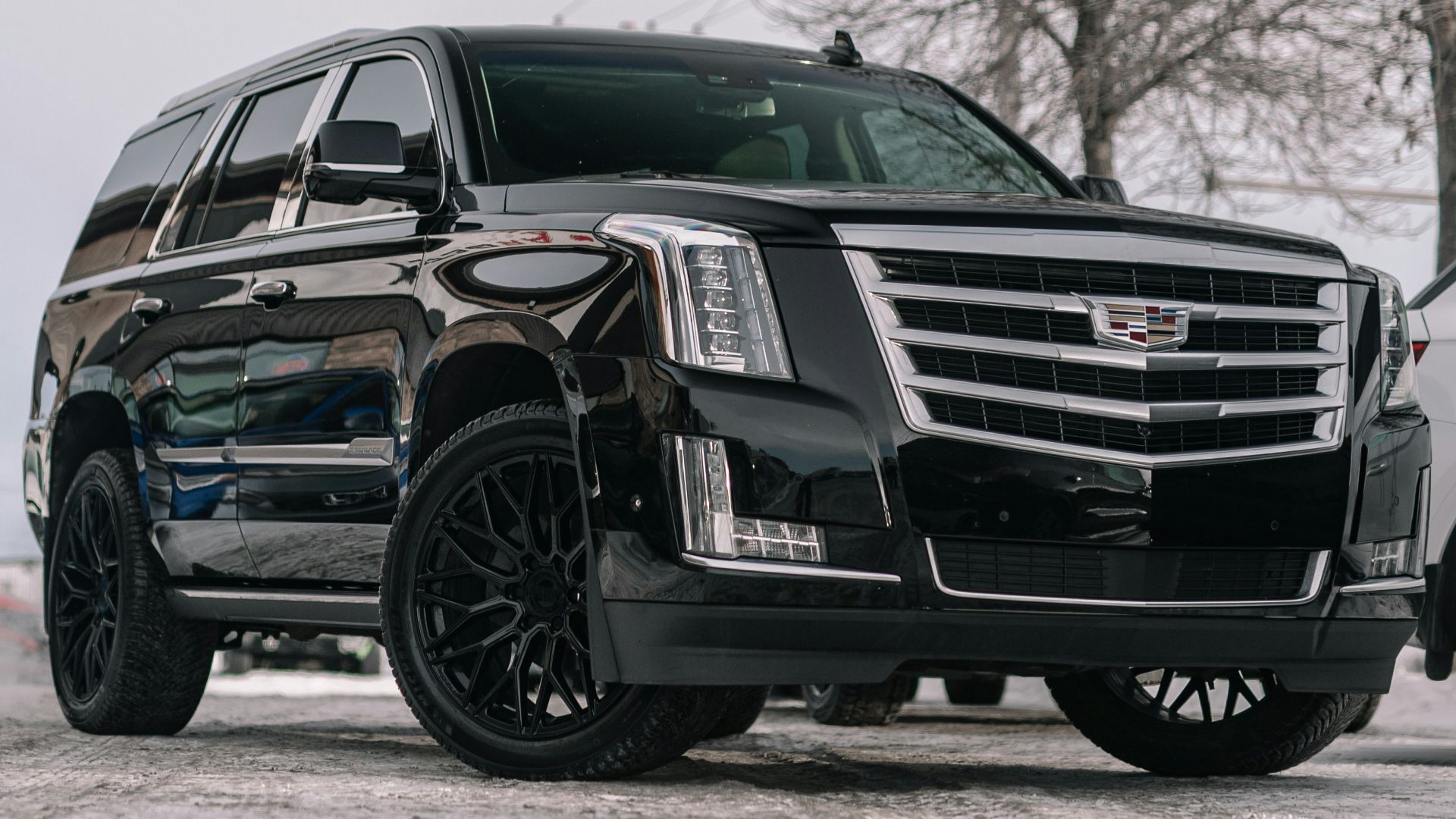 A black cadillac parked in a parking lot