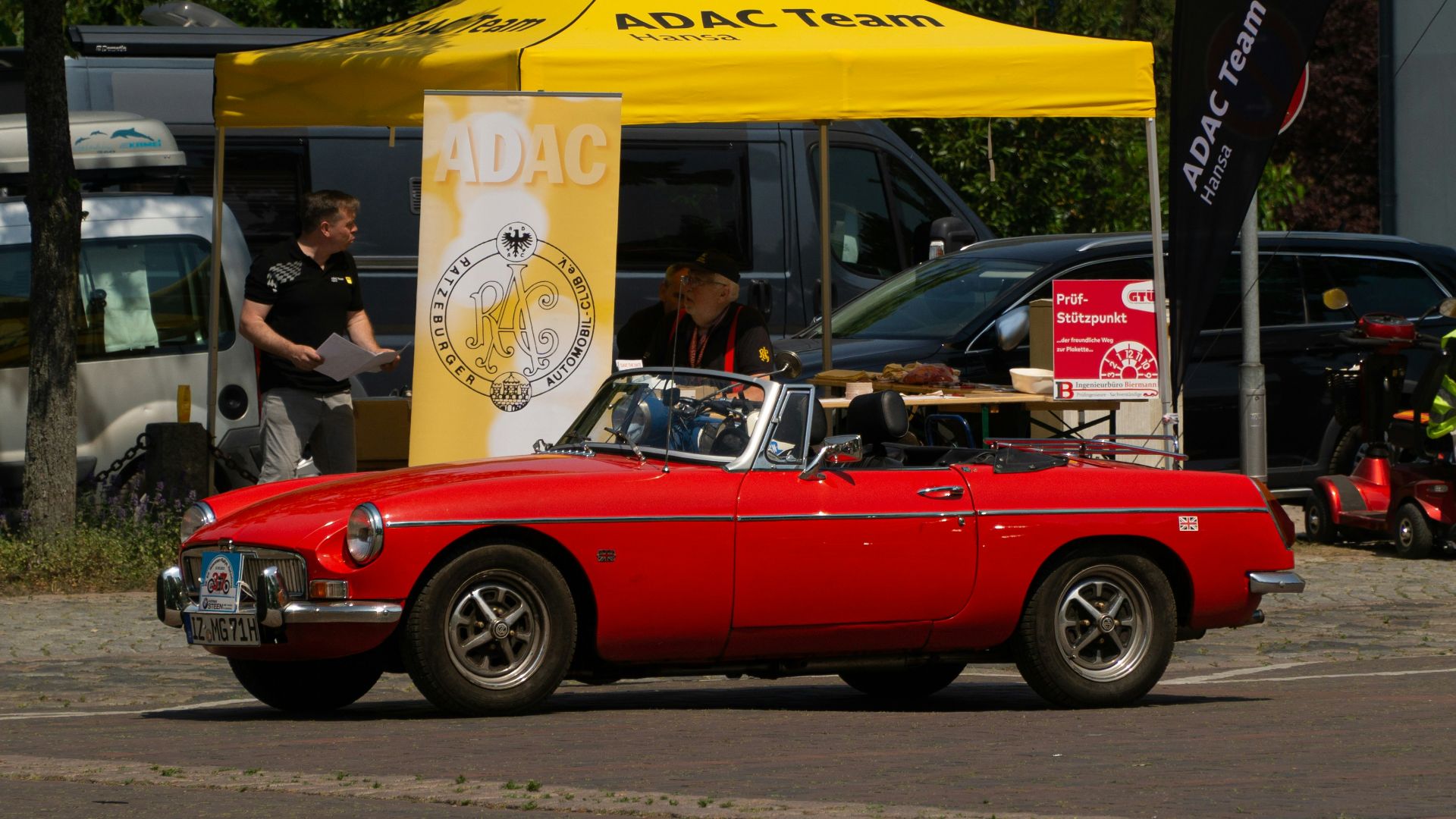 a red convertible car parked in front of a yellow tent