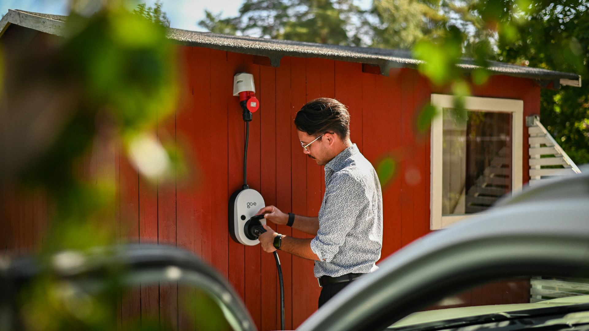 Man plugging in an electric car charger.