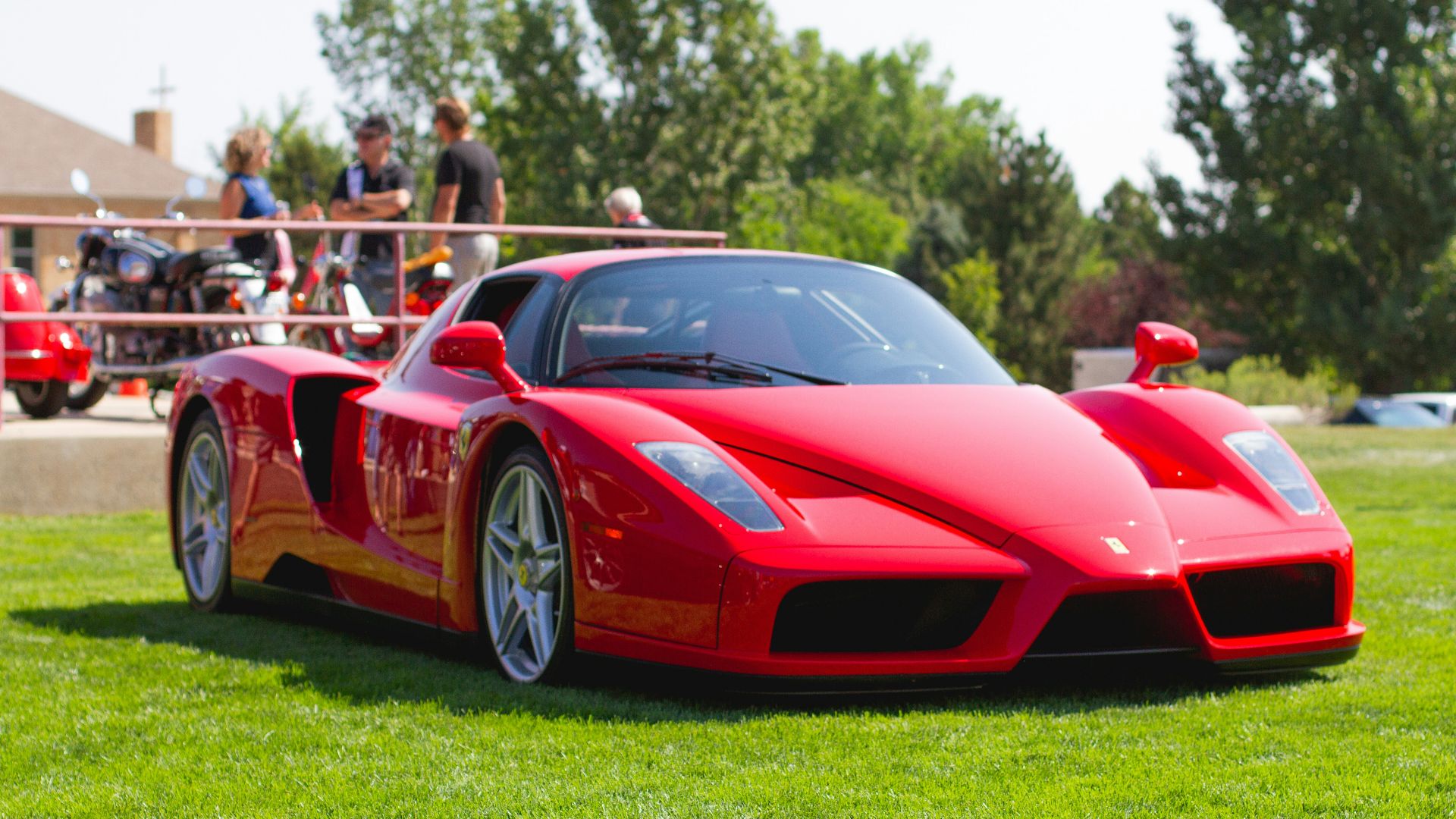 red ferrari 458 italia on green grass field during daytime