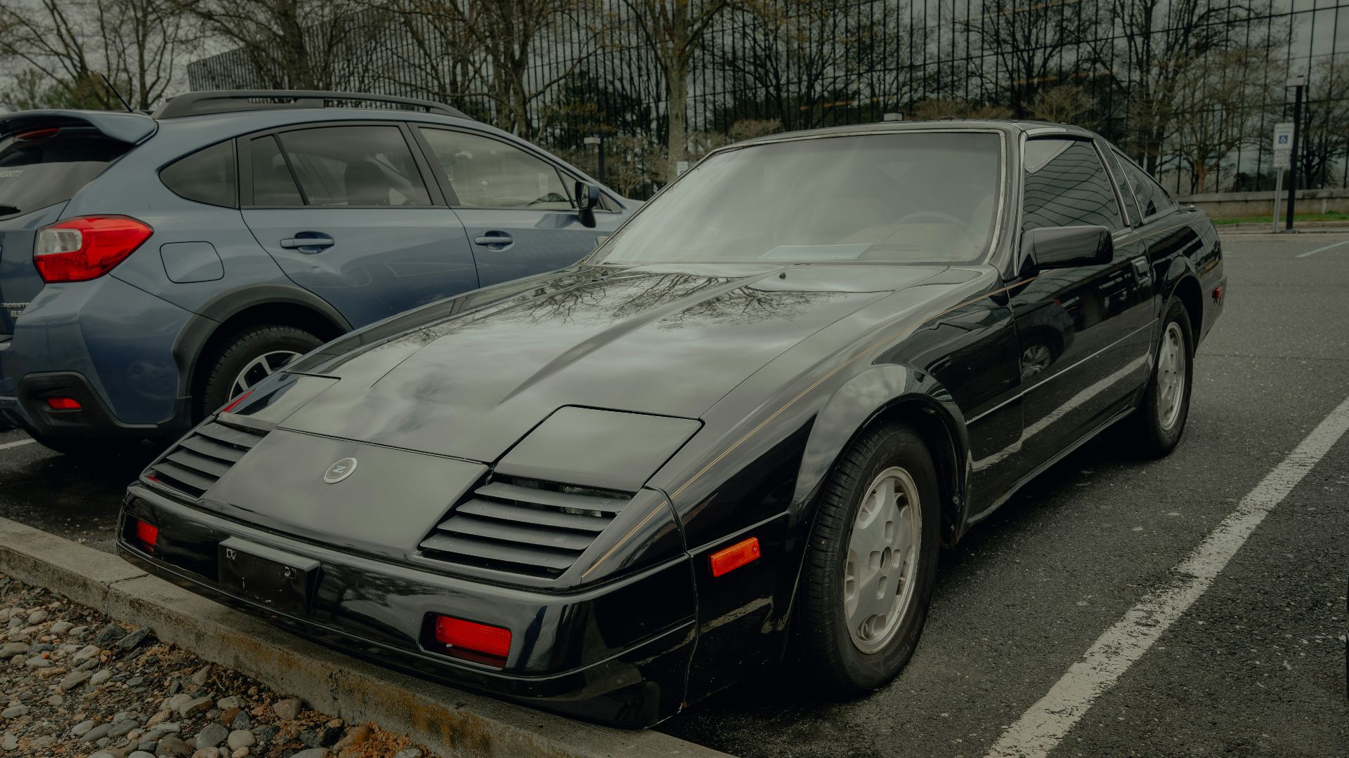 A black sports car parks in a parking lot.