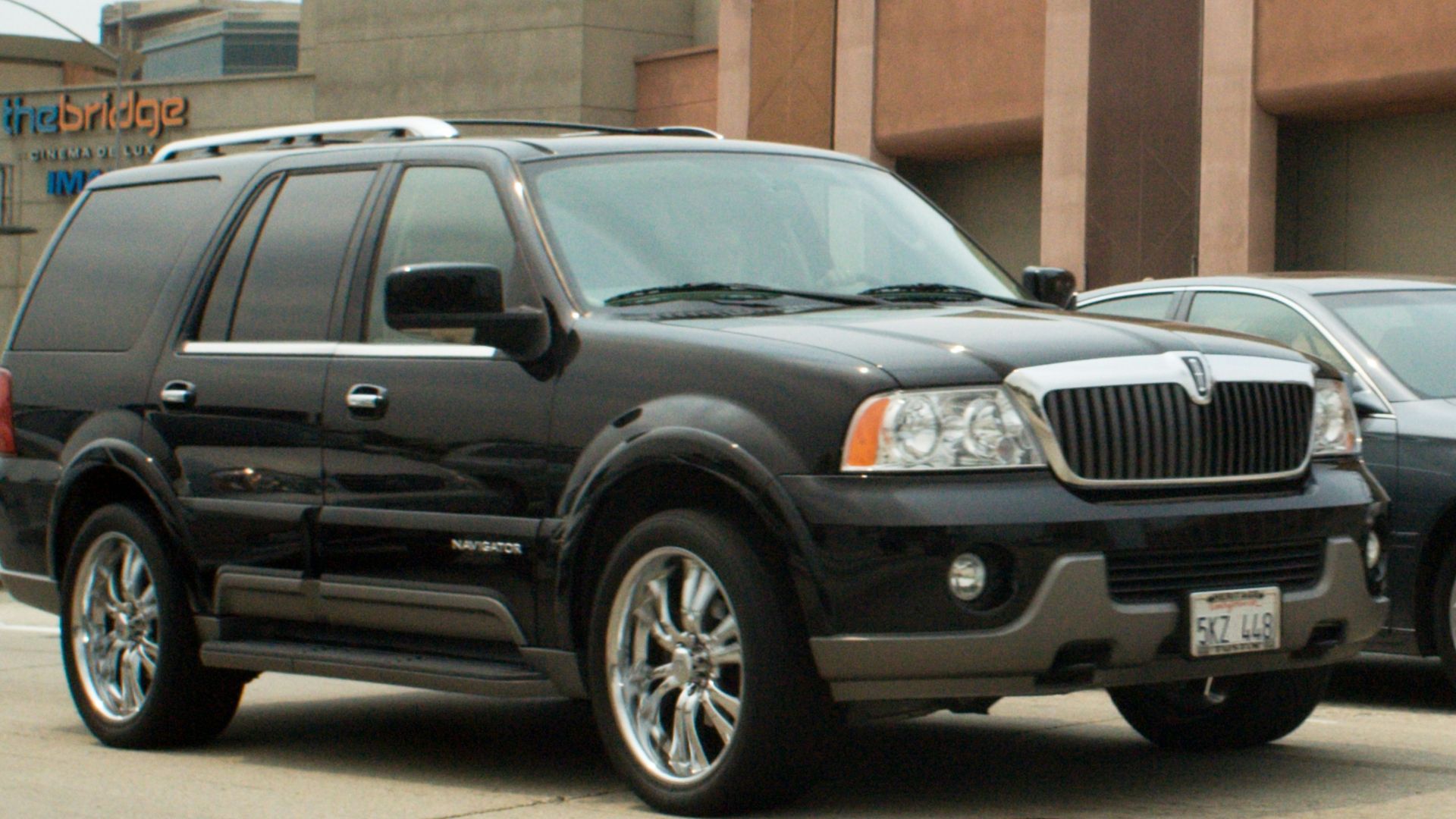 Black lincoln navigator driving on a city street.