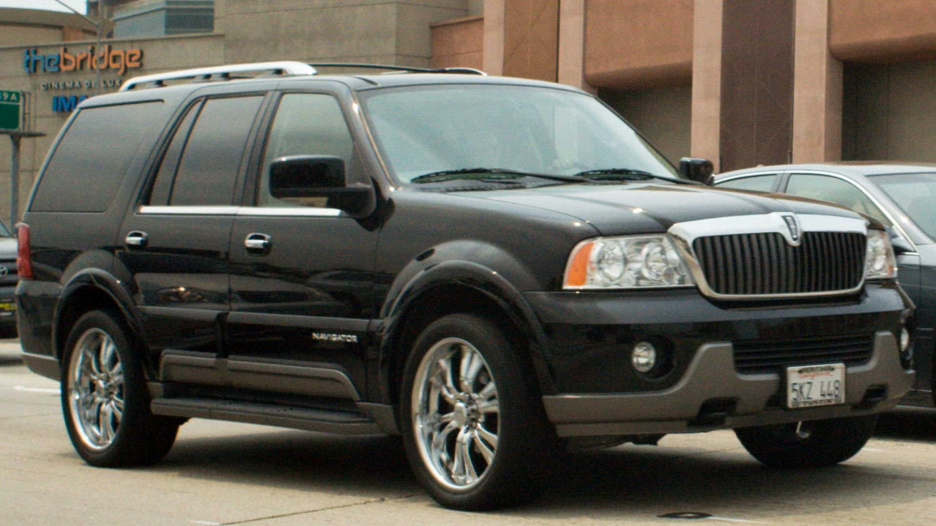 Black lincoln navigator driving on a city street.