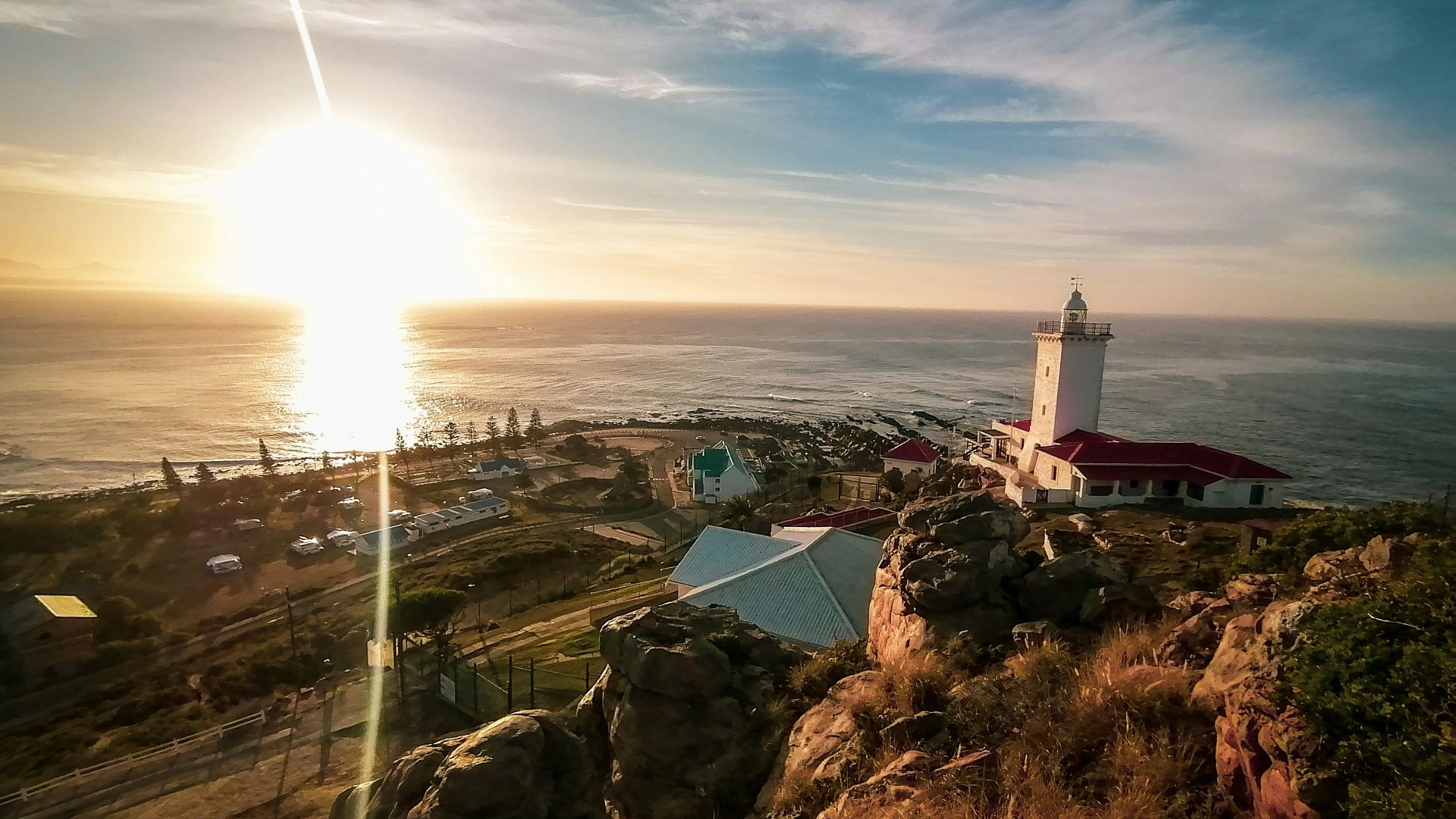 a lighthouse on top of a hill near the ocean