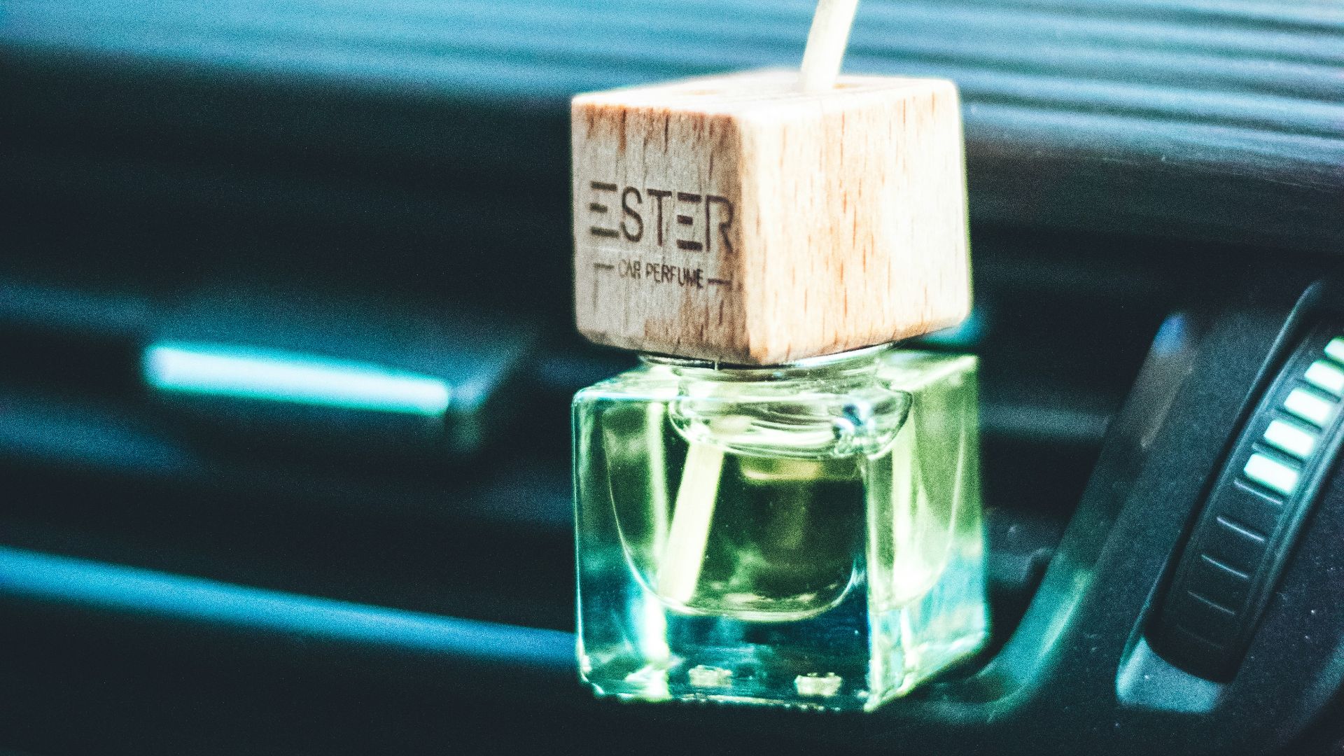a small bottle of perfume sitting on the dash of a car