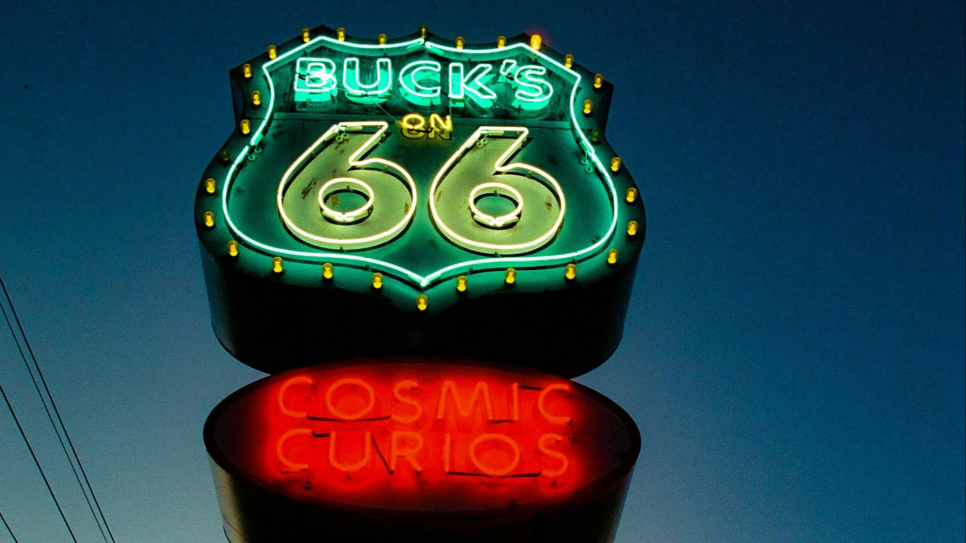 a neon sign for a toy store with a sky background
