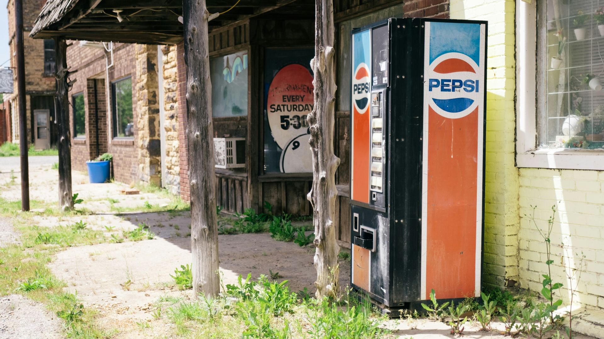 An old pepsi vending machine sits outside.