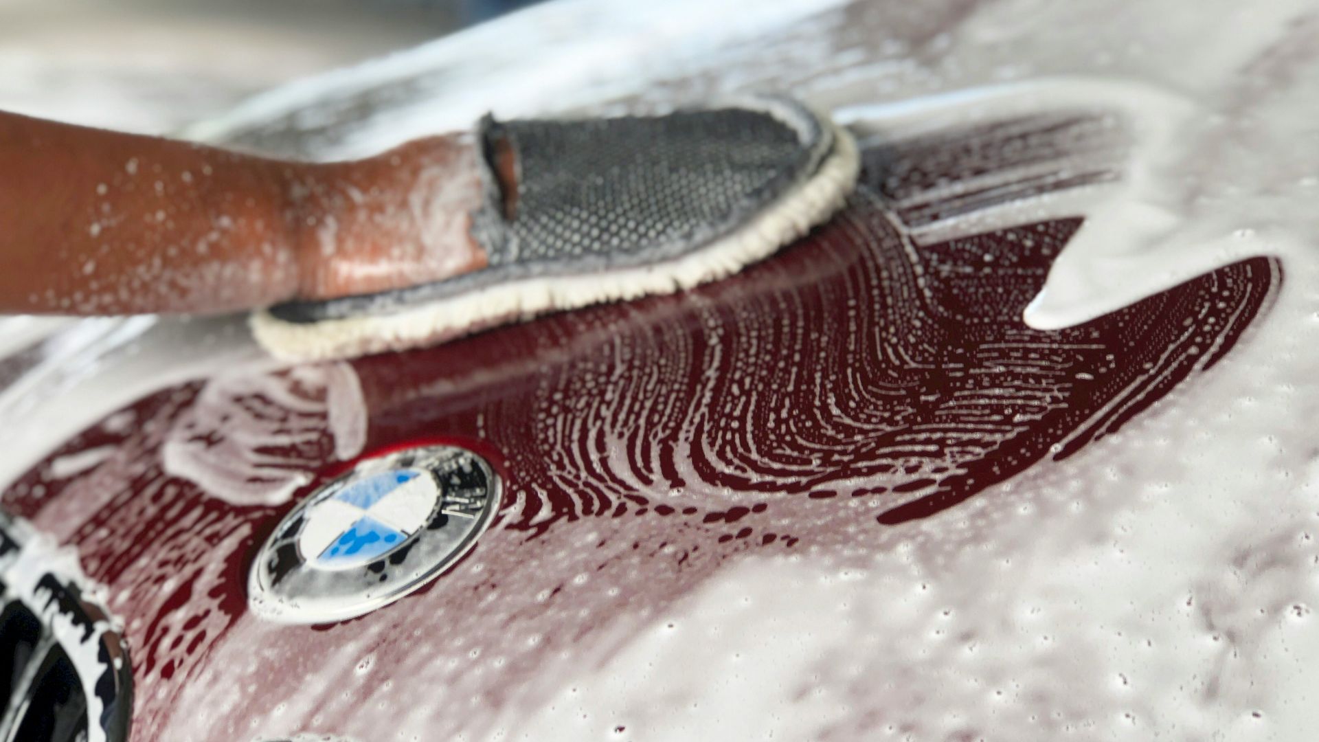 a person washing a car with a sponge