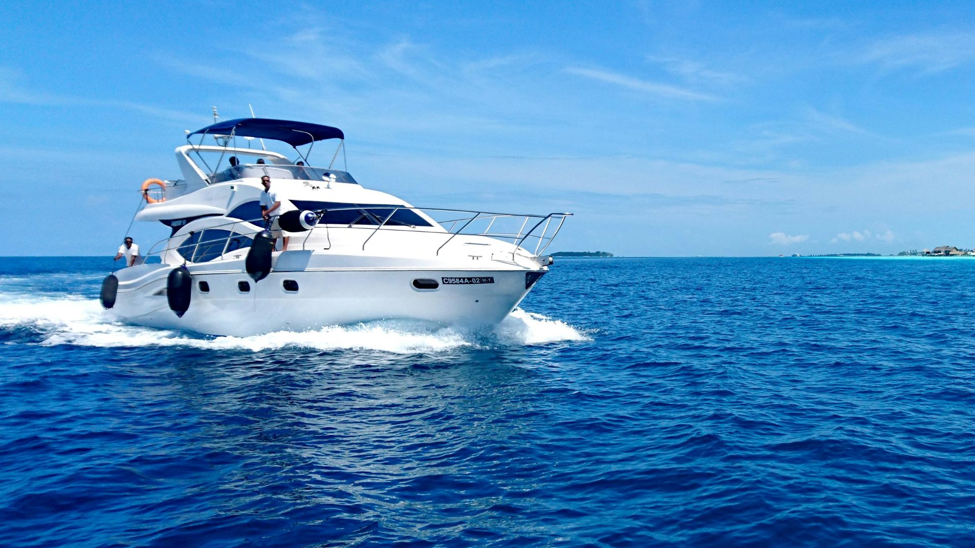 white and blue yacht on sea under blue sky during daytime