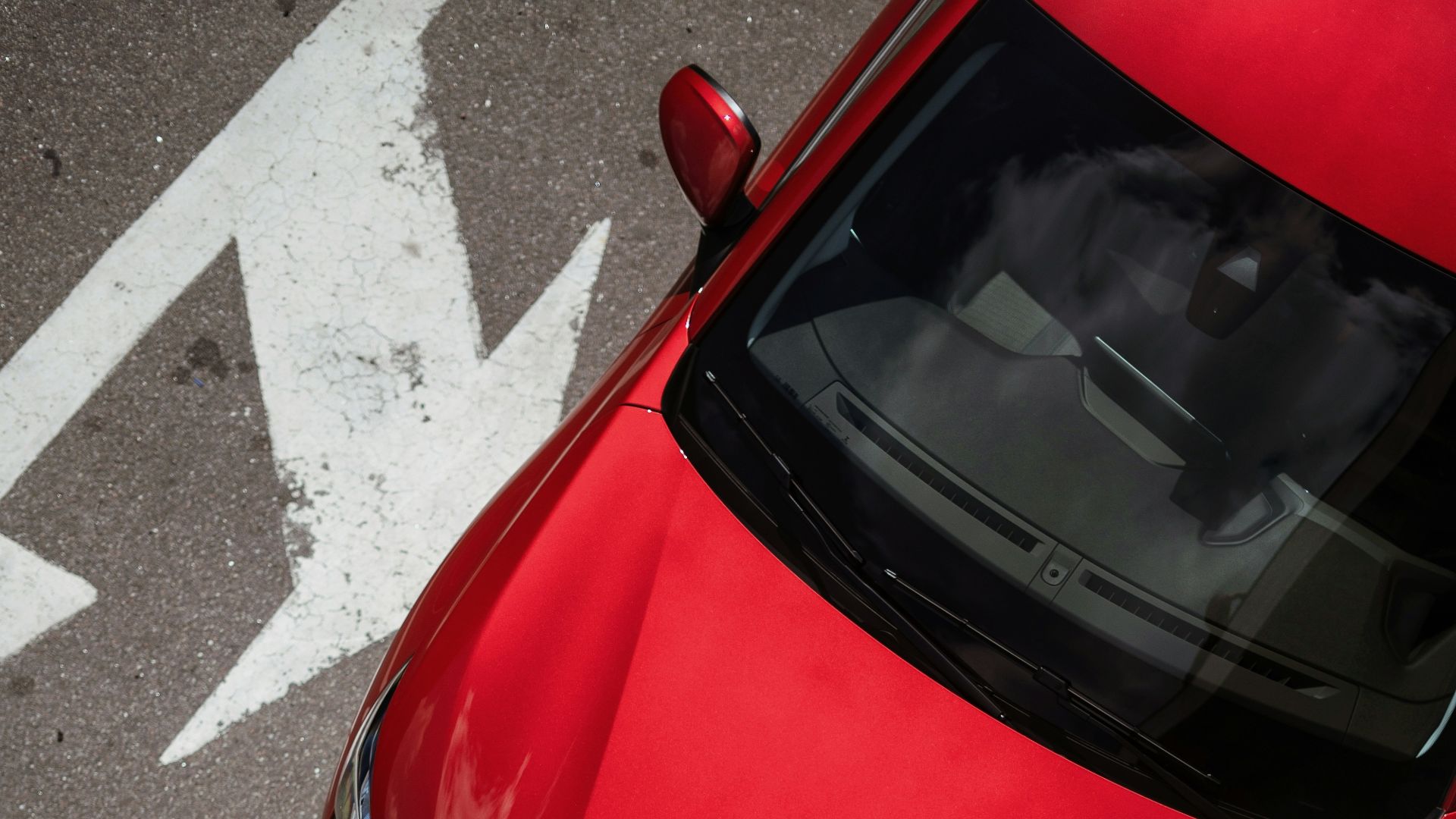 a red car is parked in a parking lot
