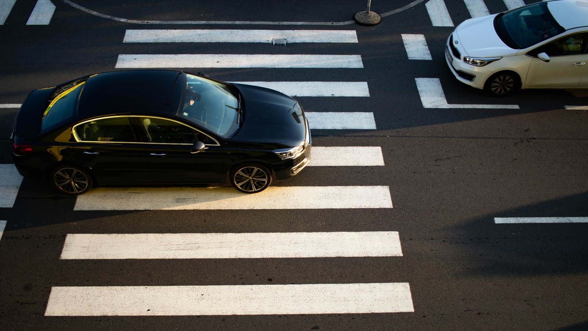 A car that is sitting in the middle of a cross walk
