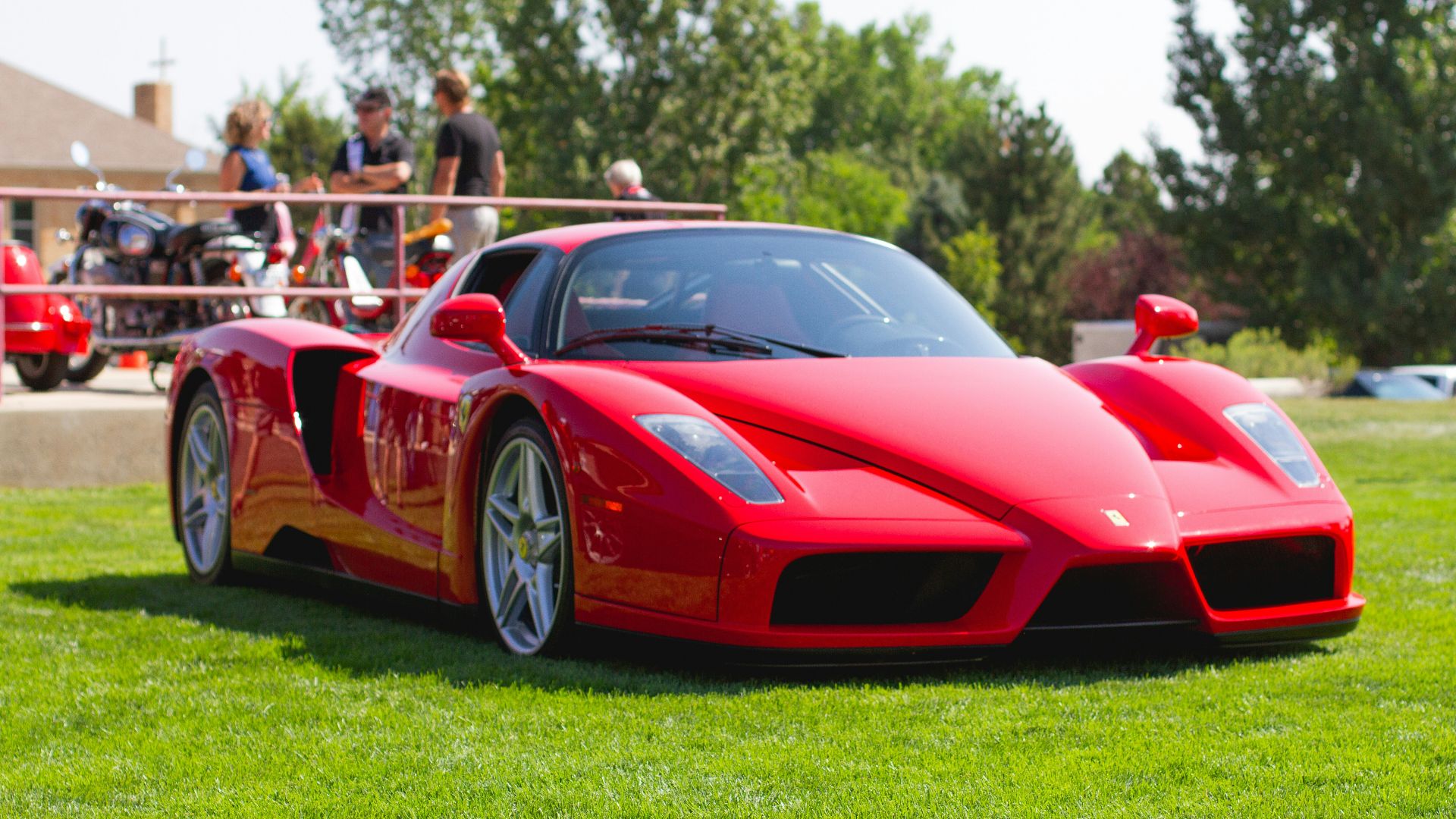 red ferrari 458 italia on green grass field during daytime