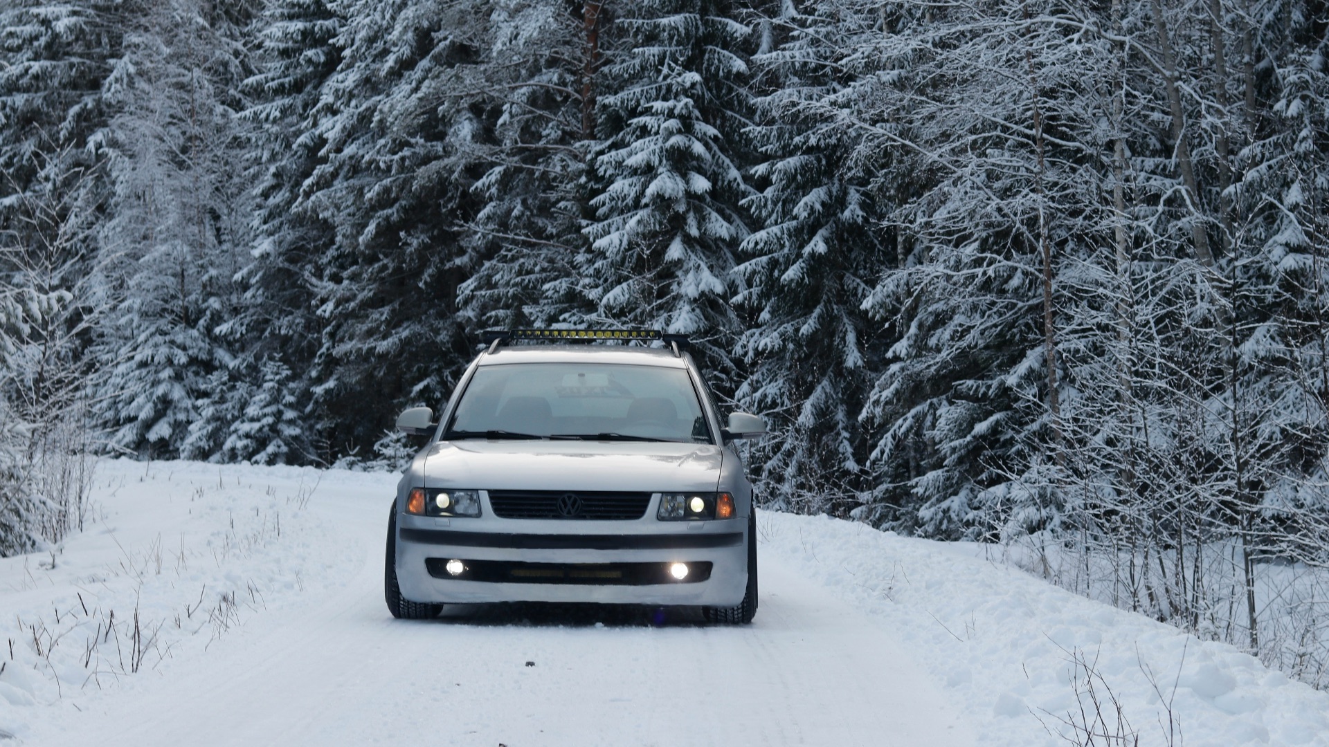 a white truck driving down a snow covered road