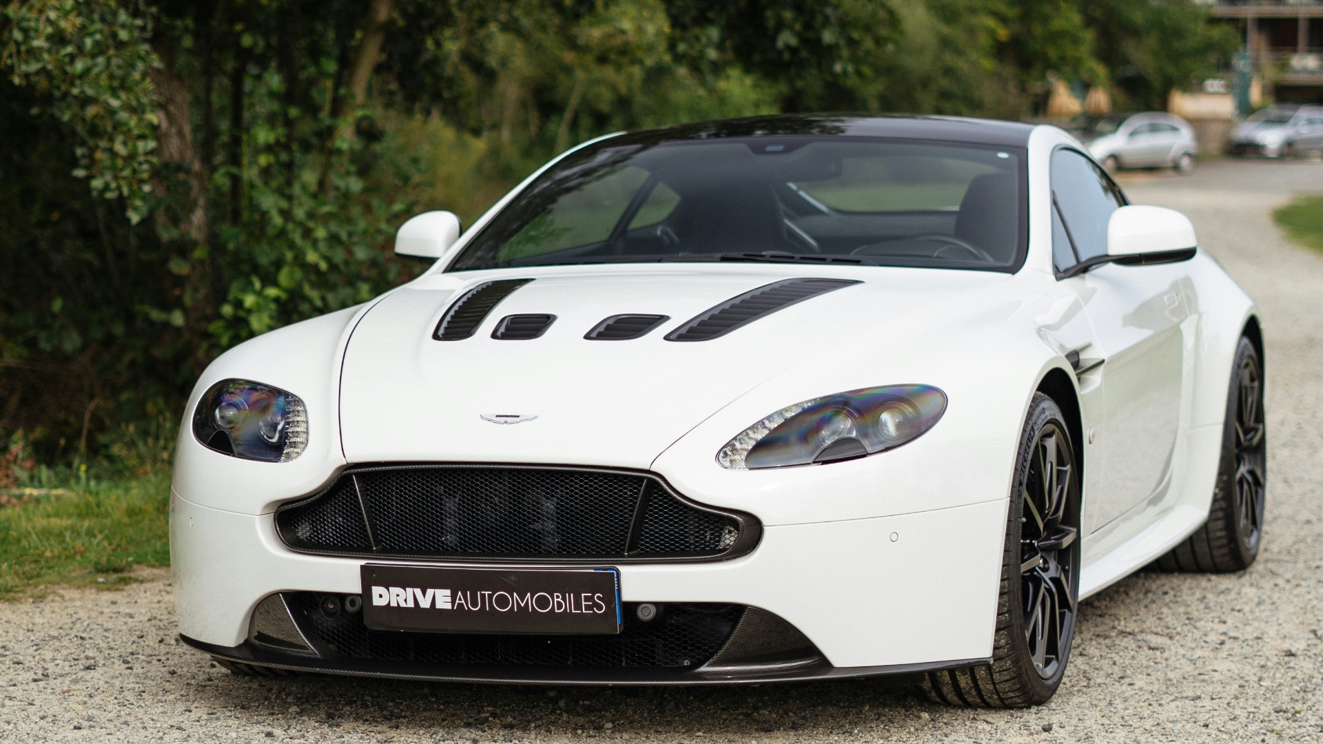 a white sports car parked on a gravel road