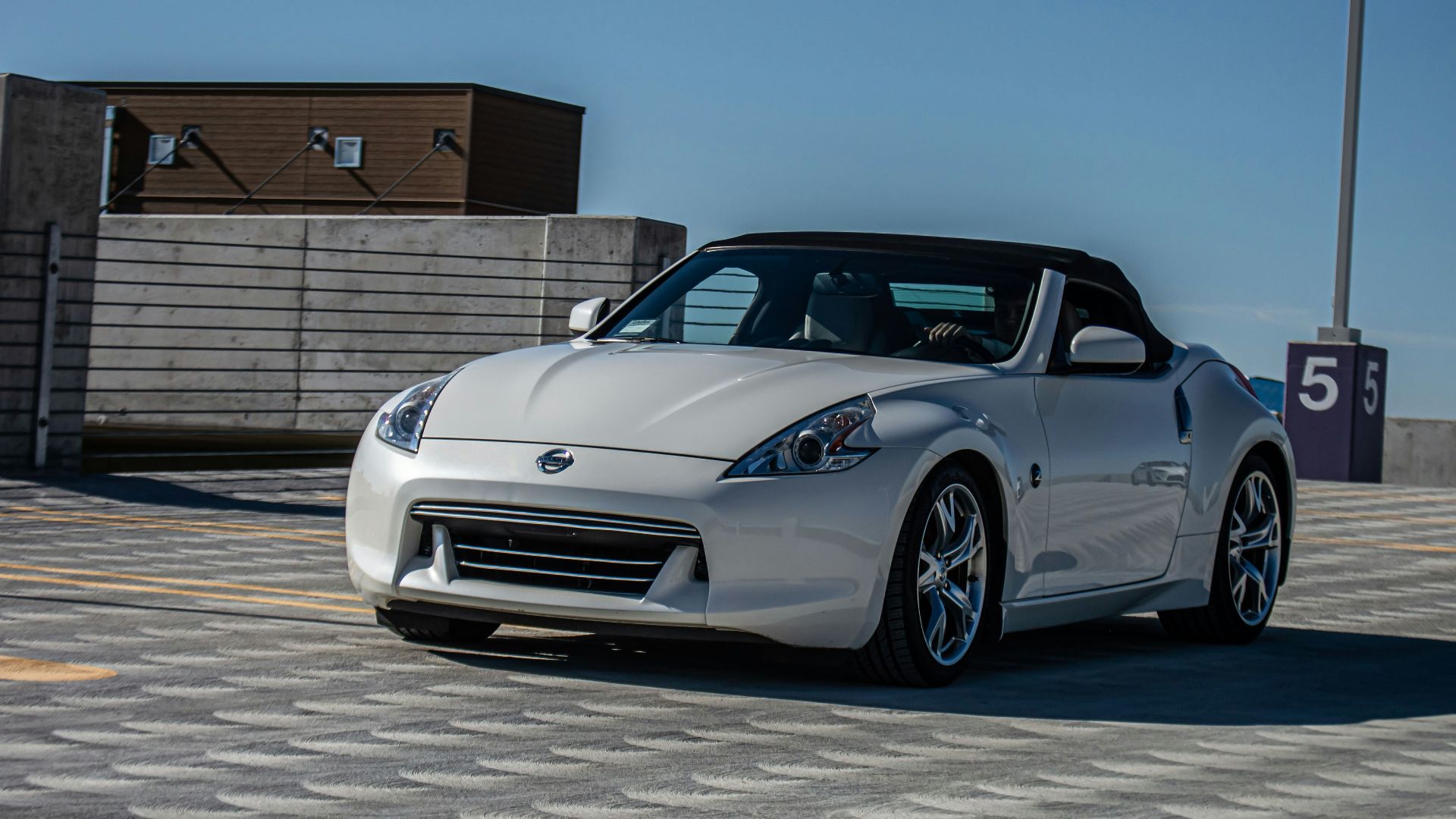 a silver sports car driving down a street
