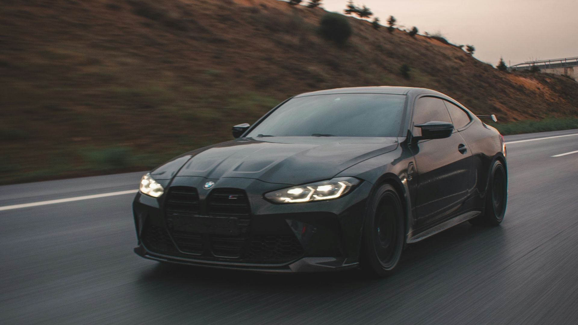 a black sports car driving down the road