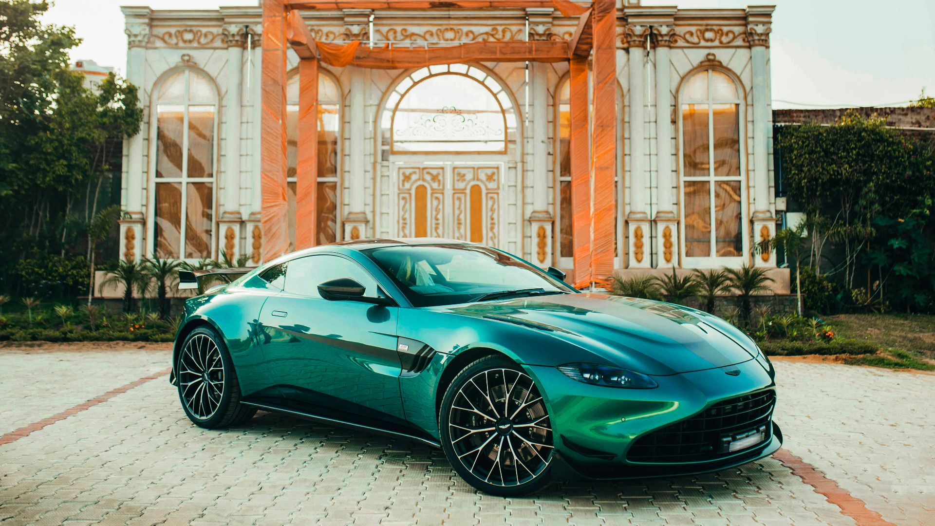 A green sports car parked in front of a building