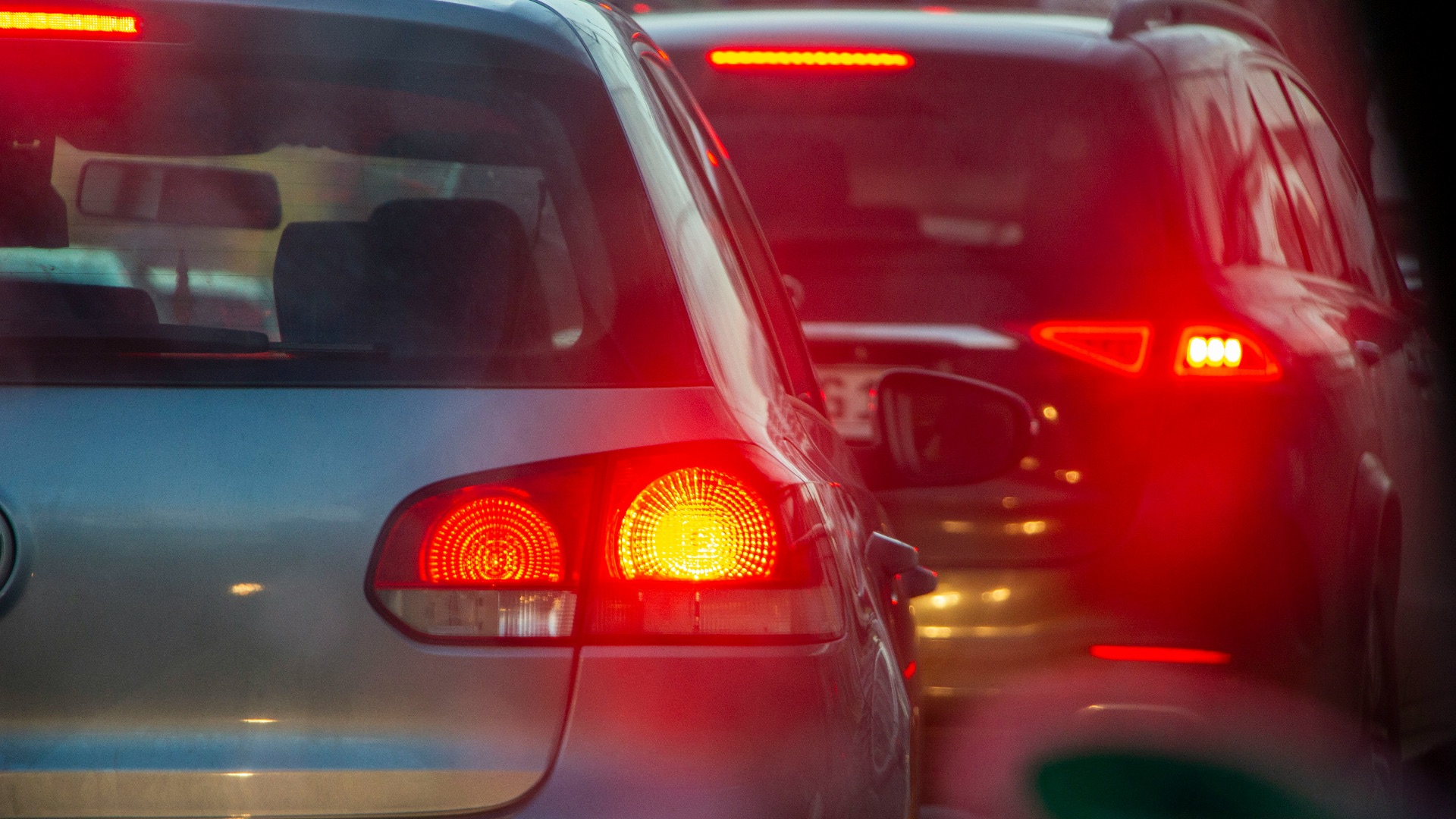 a group of cars driving down a street next to each other