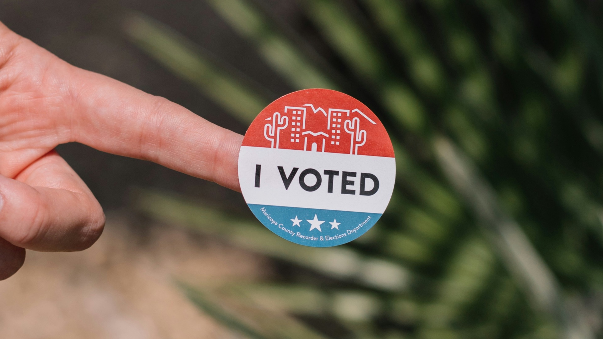 person holding red and white round pin