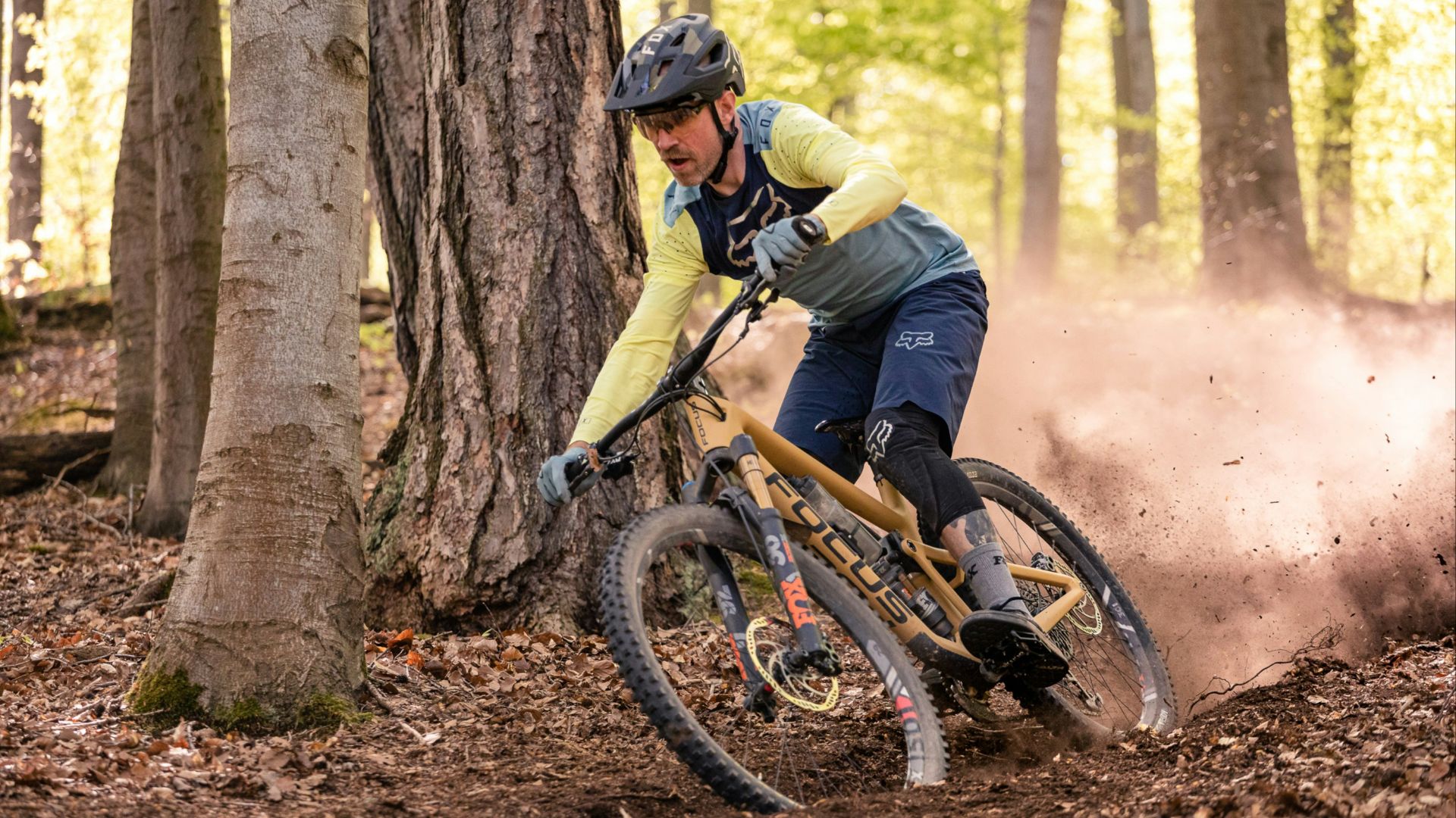 a man riding a mountain bike through a forest