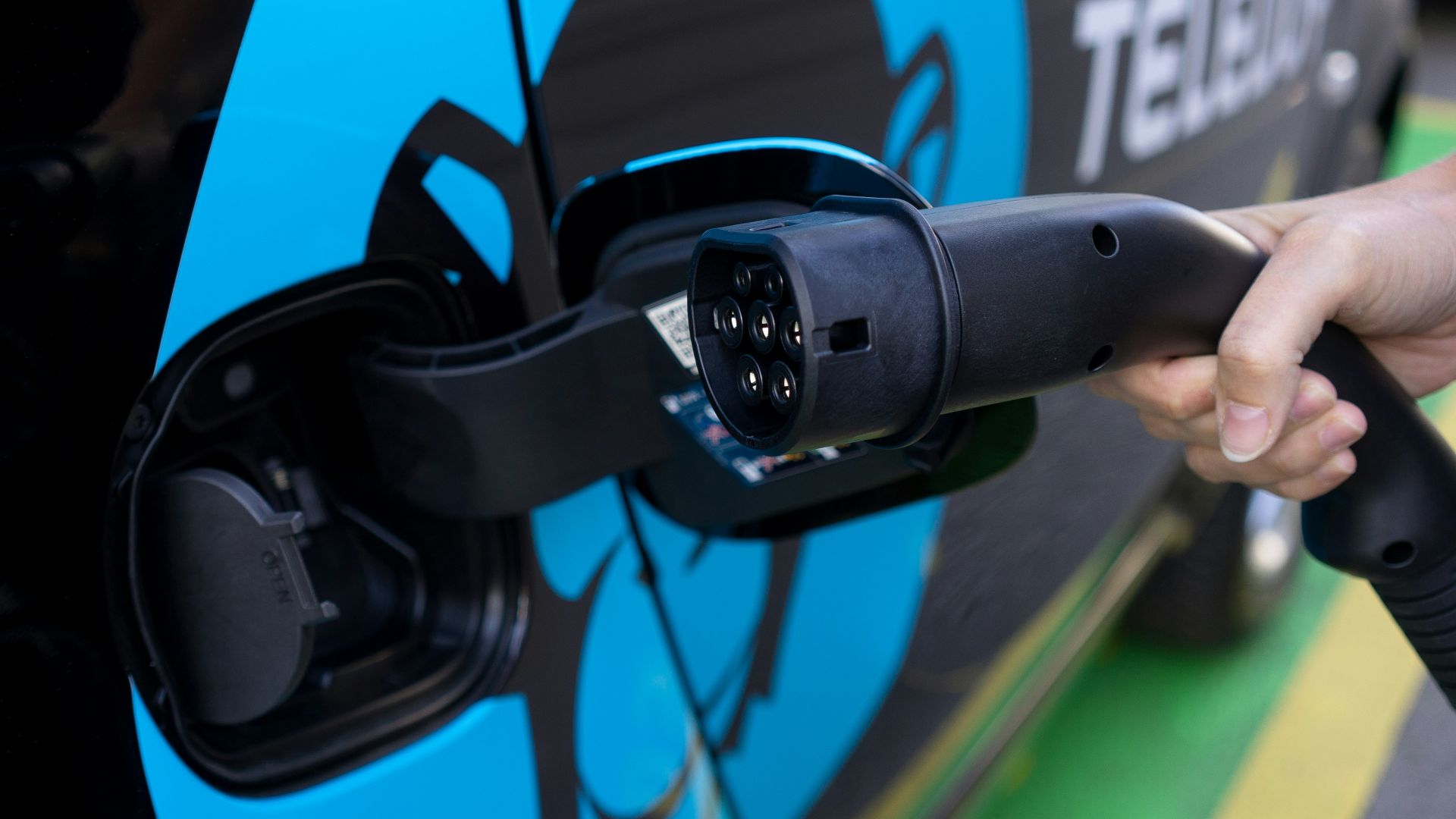 person holding black and blue bicycle helmet