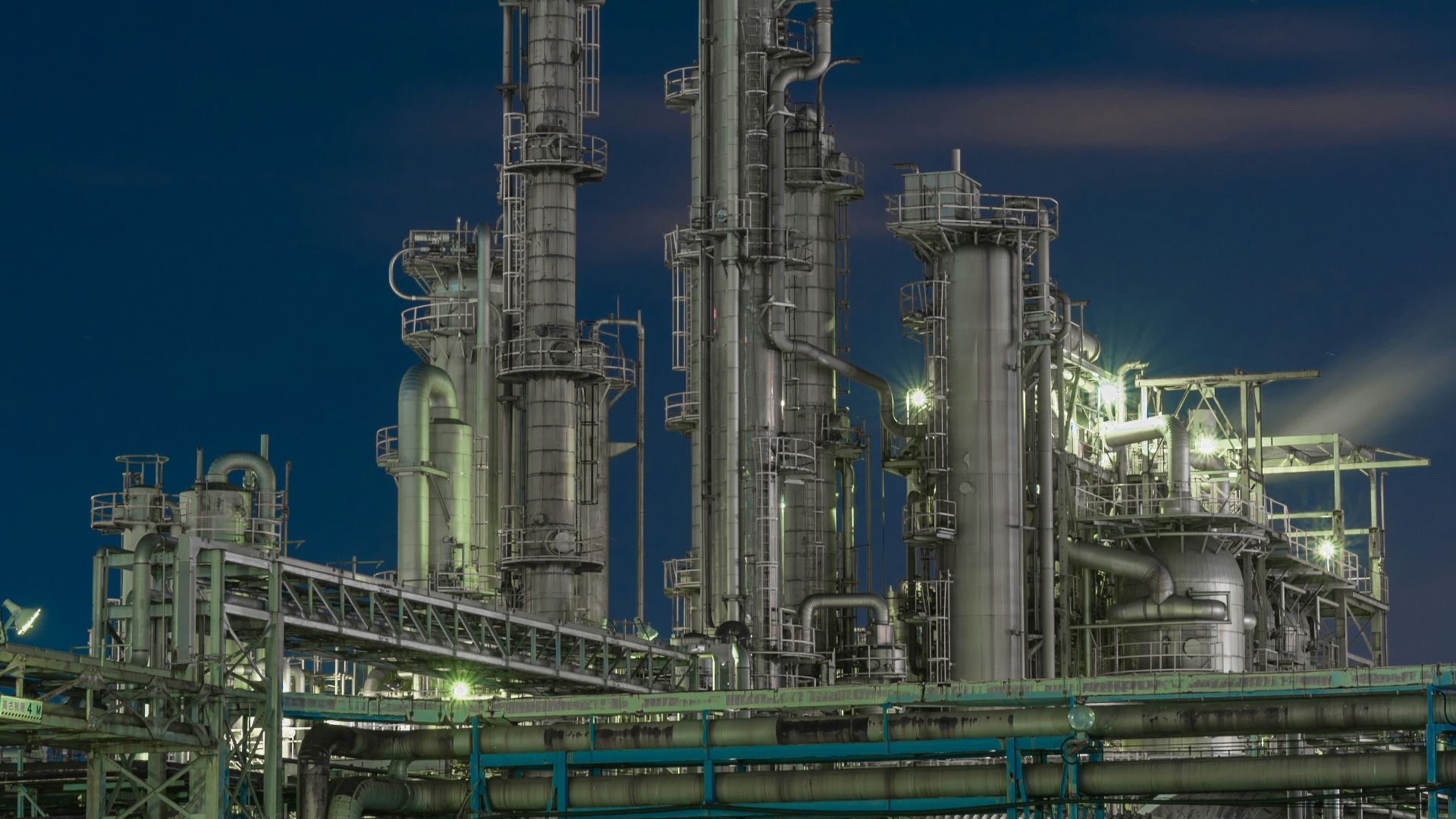 a factory with a lot of pipes and lights