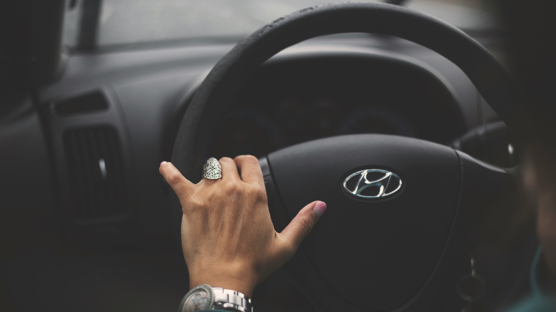 Hand on steering wheel inside car